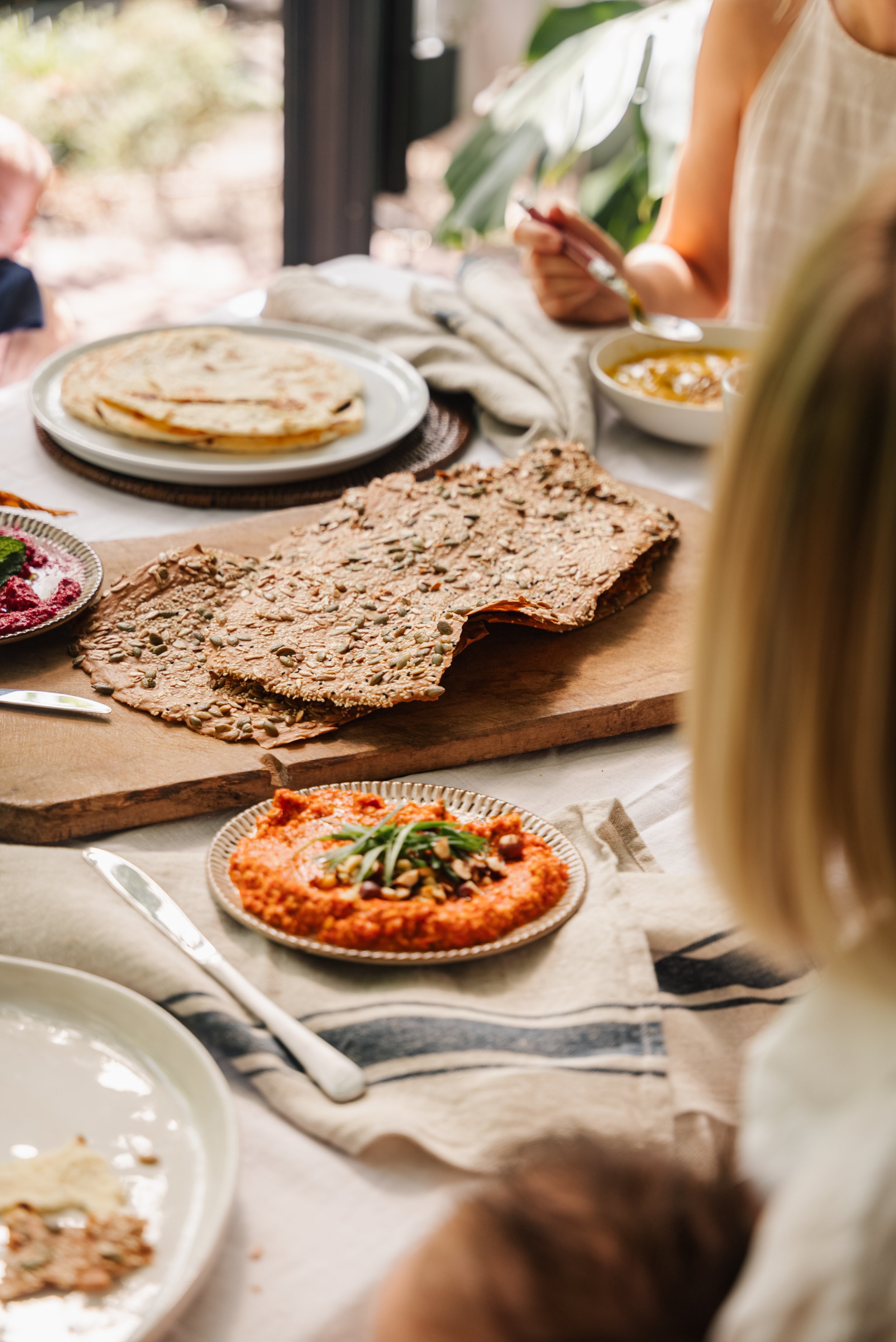 Table setting with crispbread, flatbreads, and dips