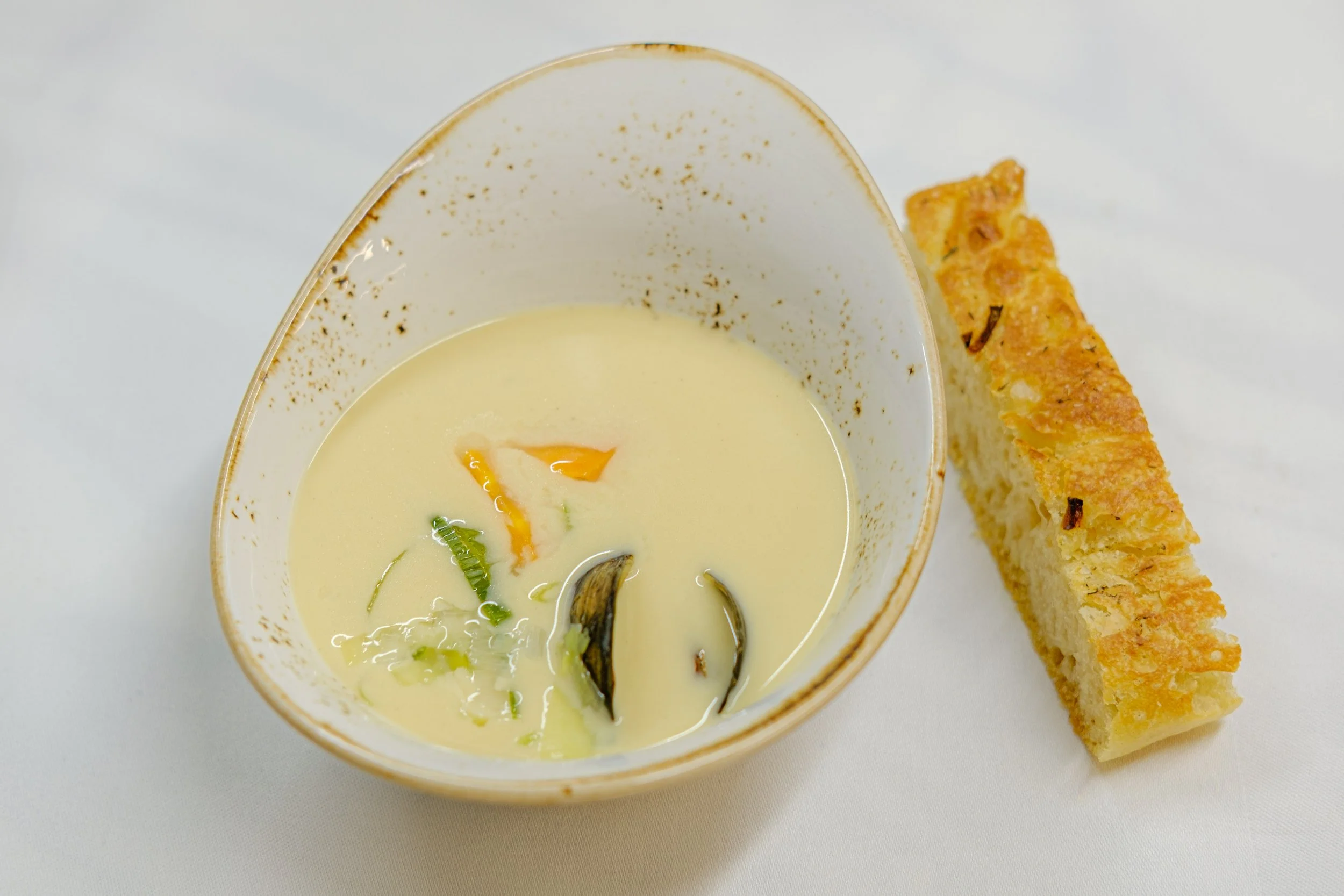 En bolle med kremet suppe og brød til. 