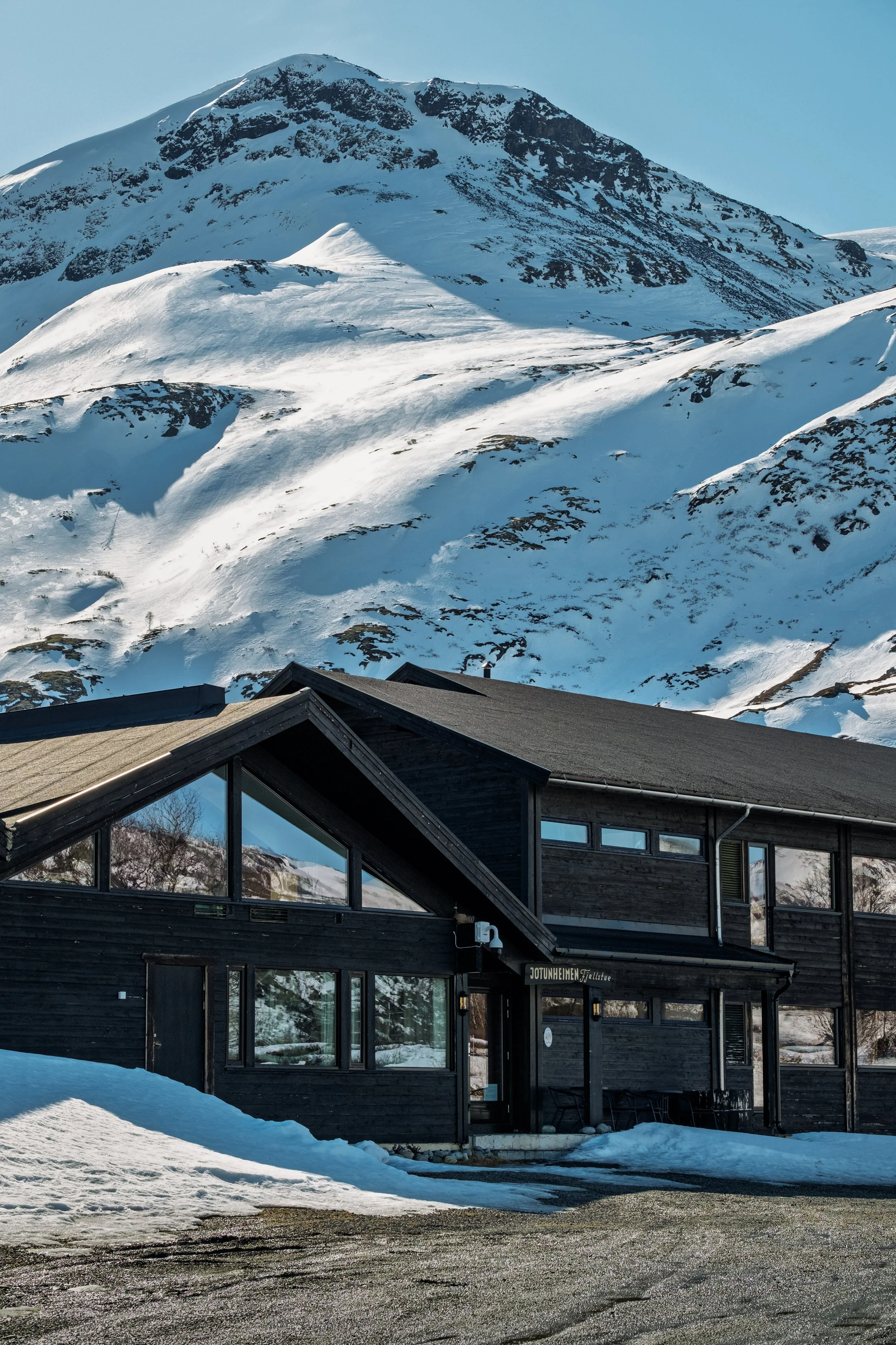 Jotunheimen Fjellstue eksteriør med utsikt mot fjelltopper og ligger langs Sognefjellsvegen