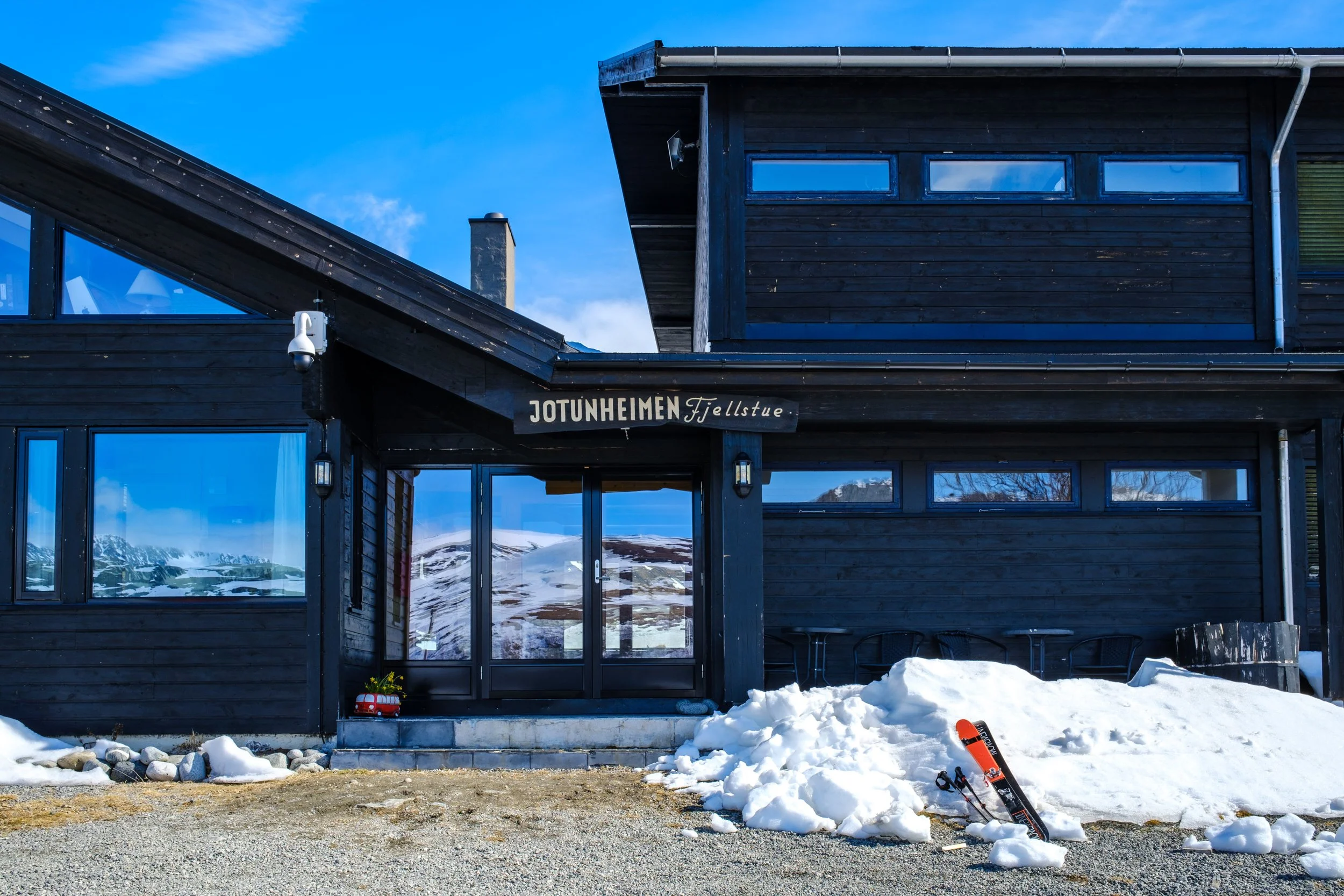 Fjellhotellet, Jotunheimen Fjellstue, i snødekt landskap med ski utstilt foran inngangen.