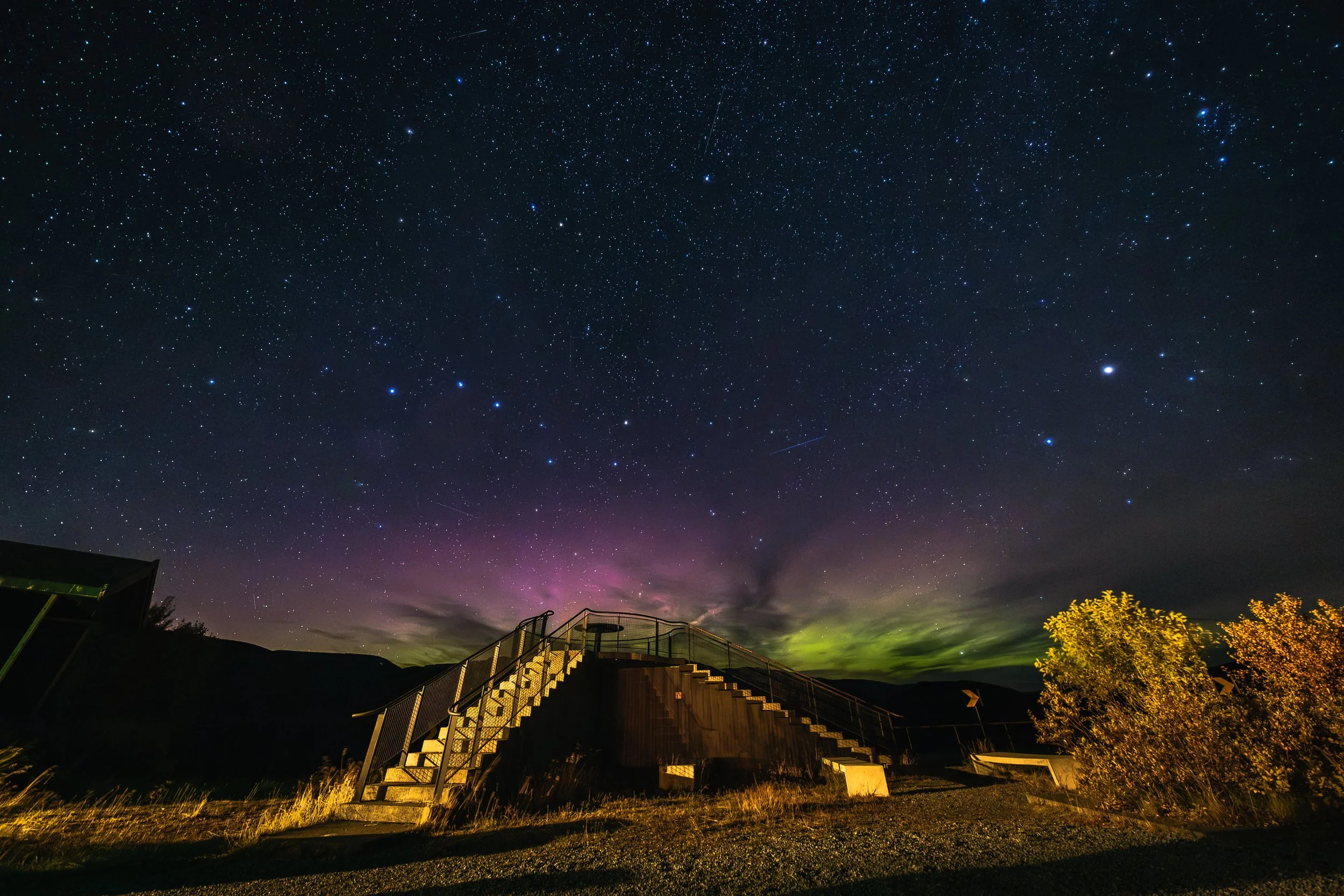 Nattlandskap med nordlys, stjerner og et utsiktspunkt som ligger på Jotunheimen Fjellstue. 