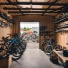 Bike storage area with bicycles parked along both sides in a wooden indoor space.