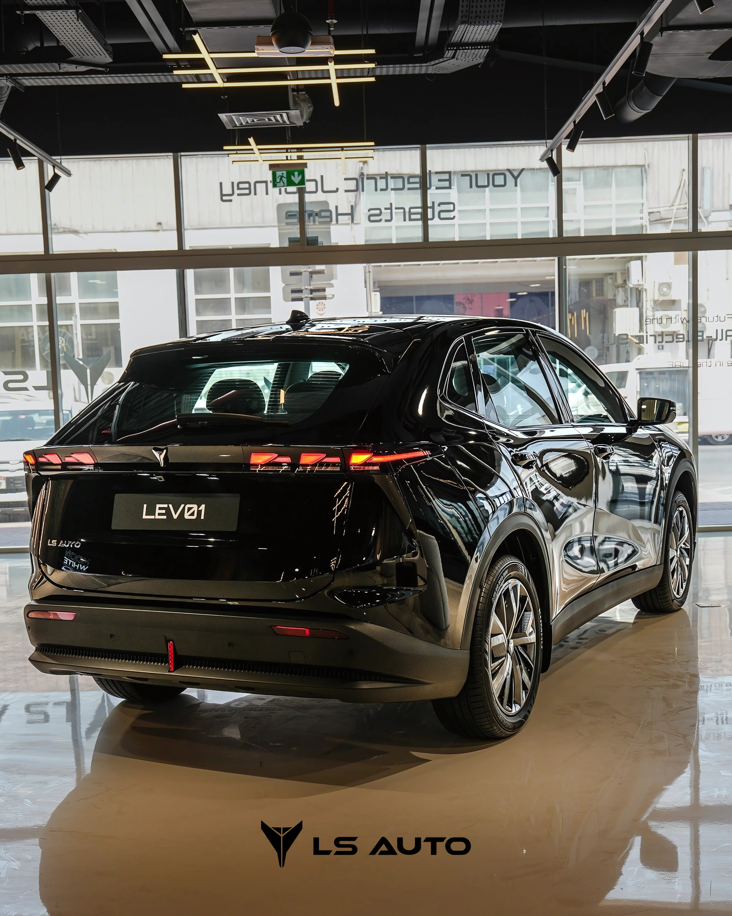 Black LEV01 electric vehicle on display inside the LS Auto UAE showroom with large windows and modern lighting.