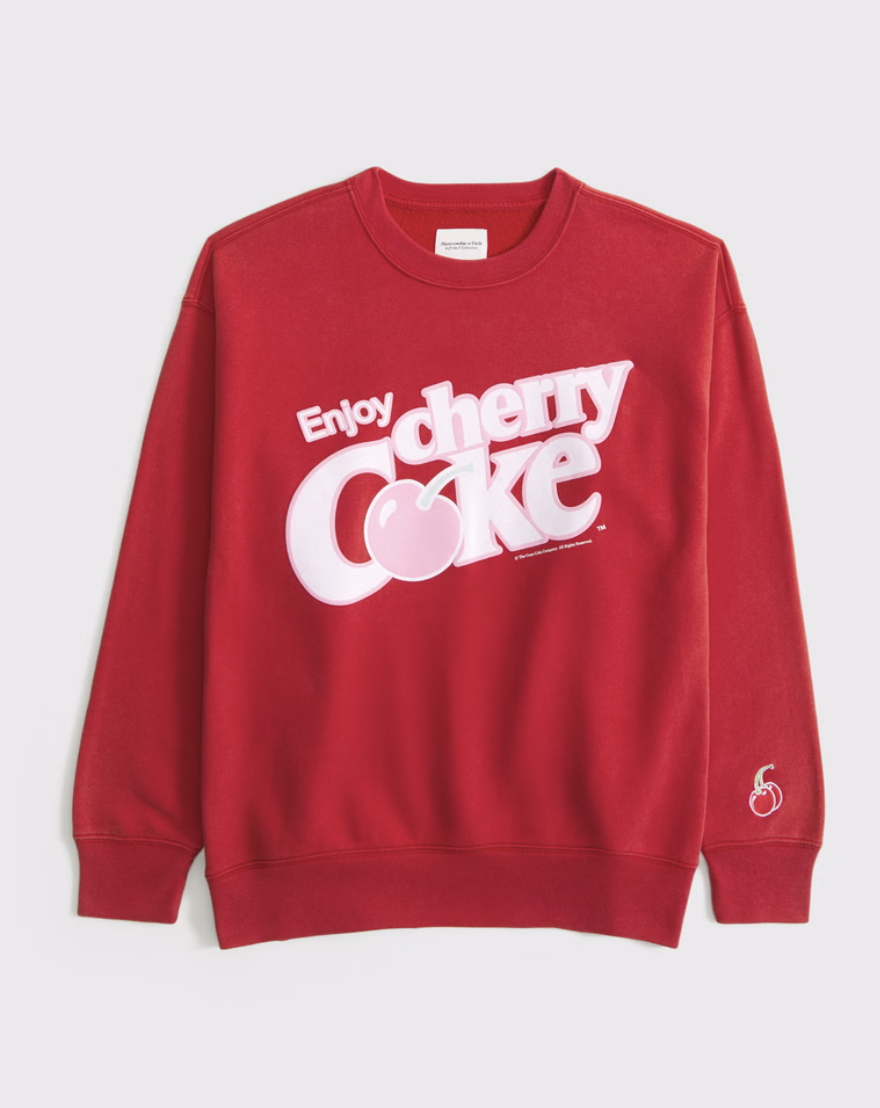 Red sweatshirt with 'Enjoy Cherry Coke' graphic design on front.