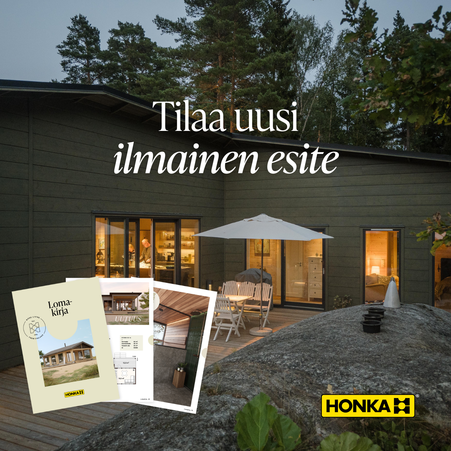 Kuva uudesta Honka-talosta ulkona ilta-aikaan, suuri terassi ja iso valkoinen aurinkovarjo, sisällä näkyy sisustus ja kaksi ihmistä keittiössä.