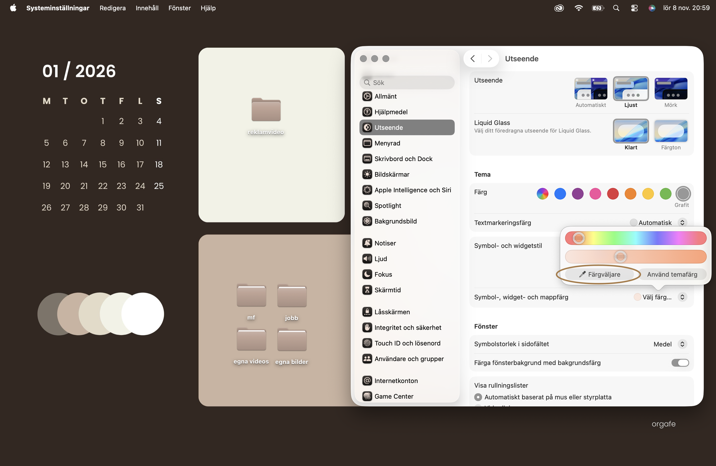 Skärmbild av en dator med inställningar för utseende, där man kan välja färg, tema och andra visuella alternativ, samt en kalender för januari 2026. Det finns mappar och ikoner för olika mappar såsom 'reklamvideo', 'mf', 'jobb', 'egna videor' och 'egna bilder'.