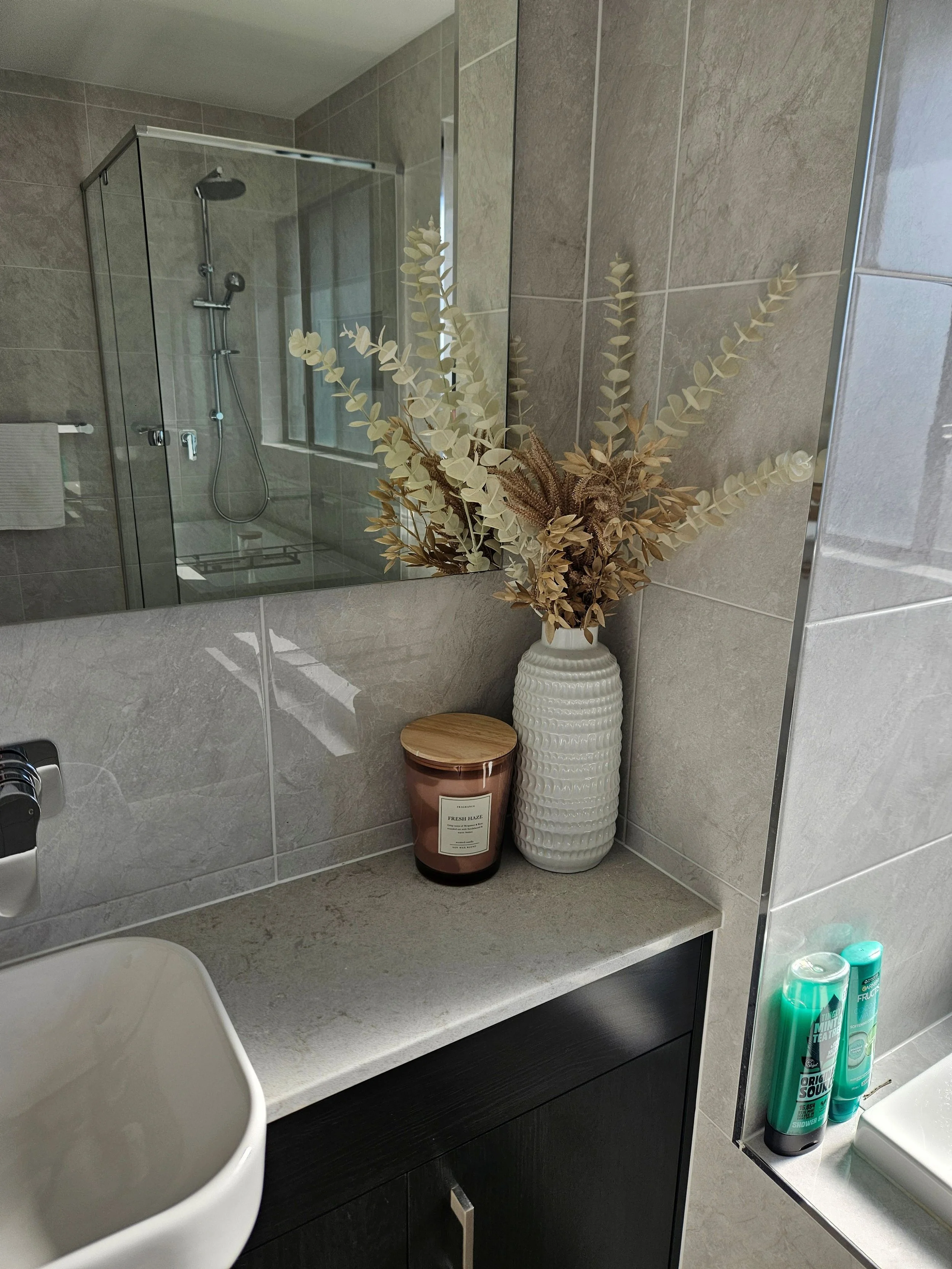 Clean and modern bathroom counter with flower and candle decor