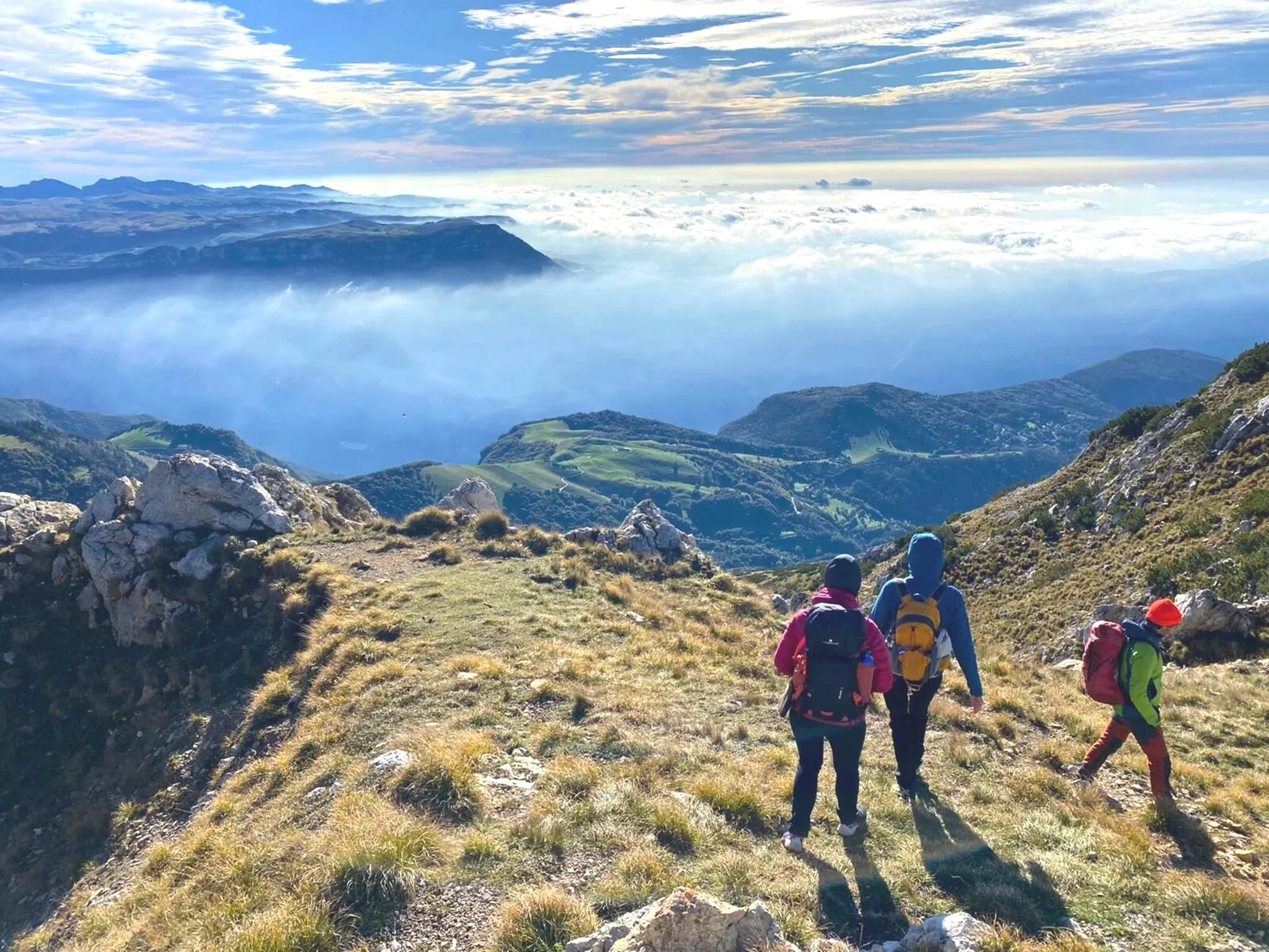 Escursionisti in cammino sul Monte Baldo con il Lago di Garda sullo sfondo