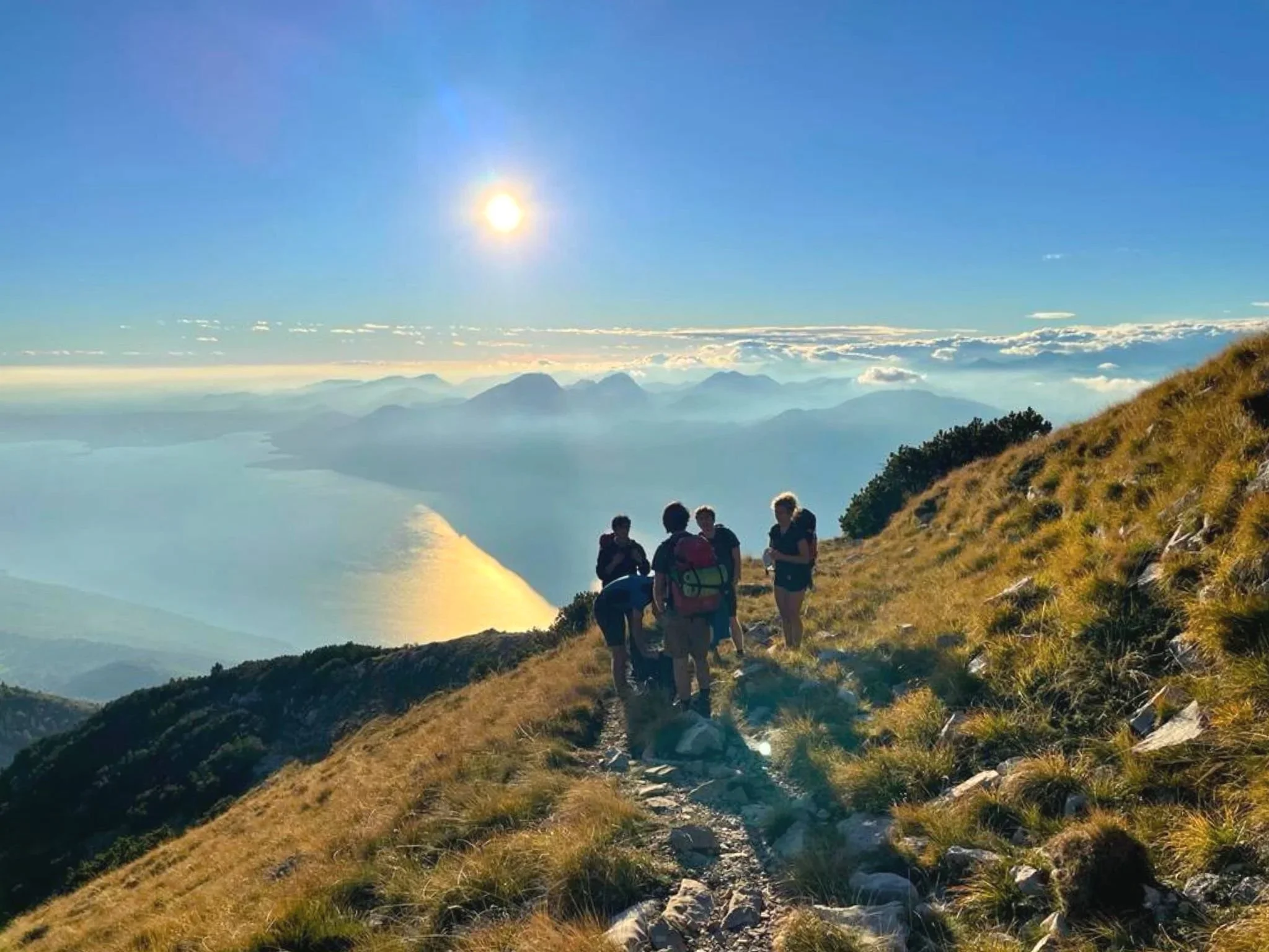 Escursionisti durante il trekking sul Monte Baldo con il Lago di Garda sullo sfondo