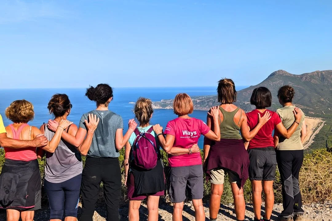 Gruppo di escursioniste sul Cammino di Santa Barbara che osservano il mare della Sardegna