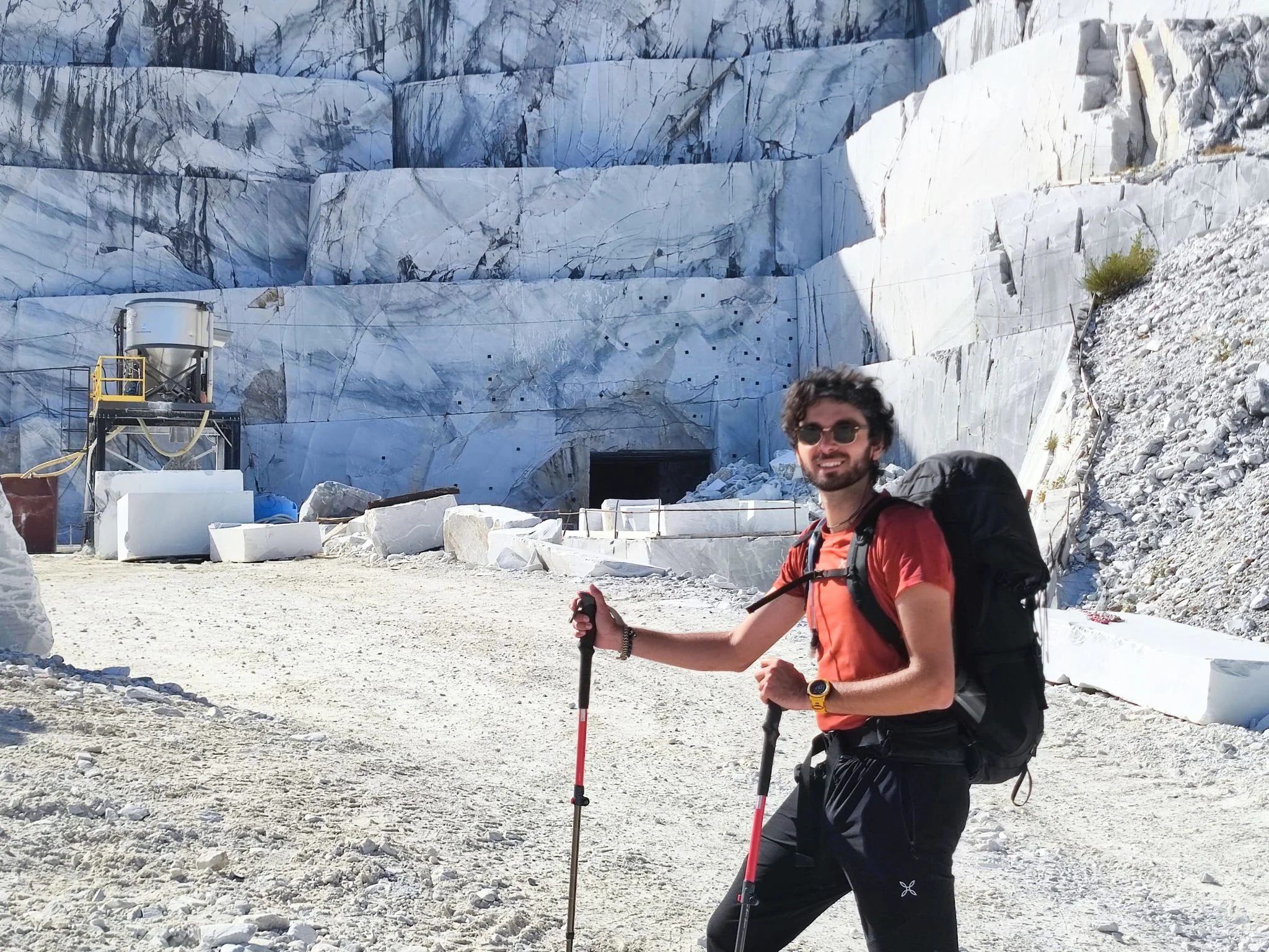 Escursionista durante un trekking nelle Alpi Apuane con le cave di marmo di Carrara sullo sfondo