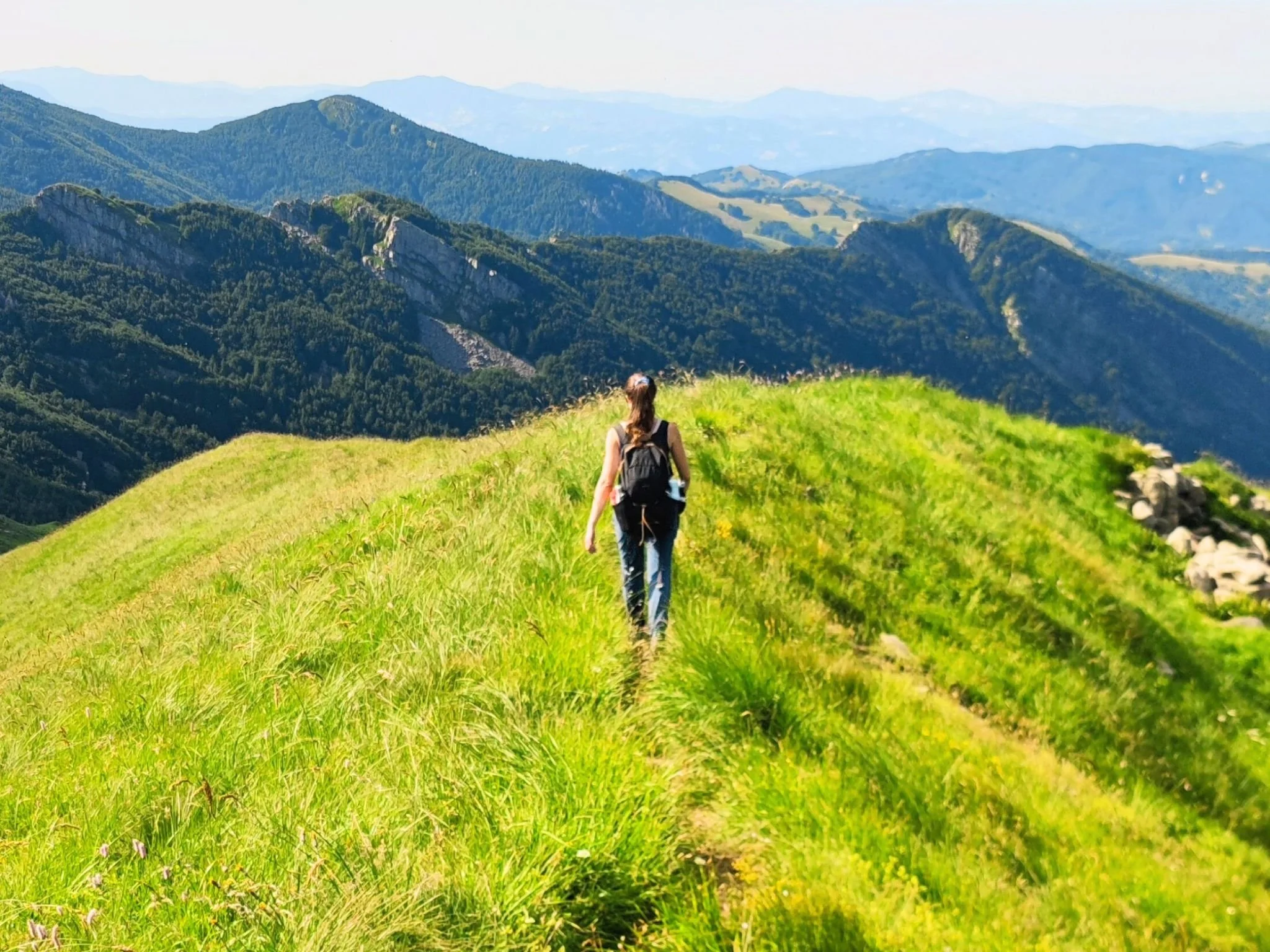 Ragazza escursionista che cammina su un crinale panoramico nel Parco dei 100 Laghi, nell’Appennino Parmense