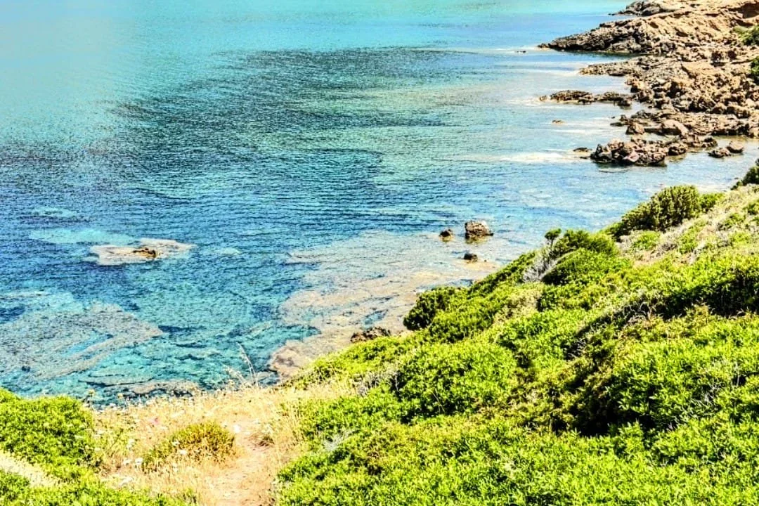 Piccola caletta dalle acque turchesi lungo il Cammino Minerario di Santa Barbara, Sardegna sud-occidentale.