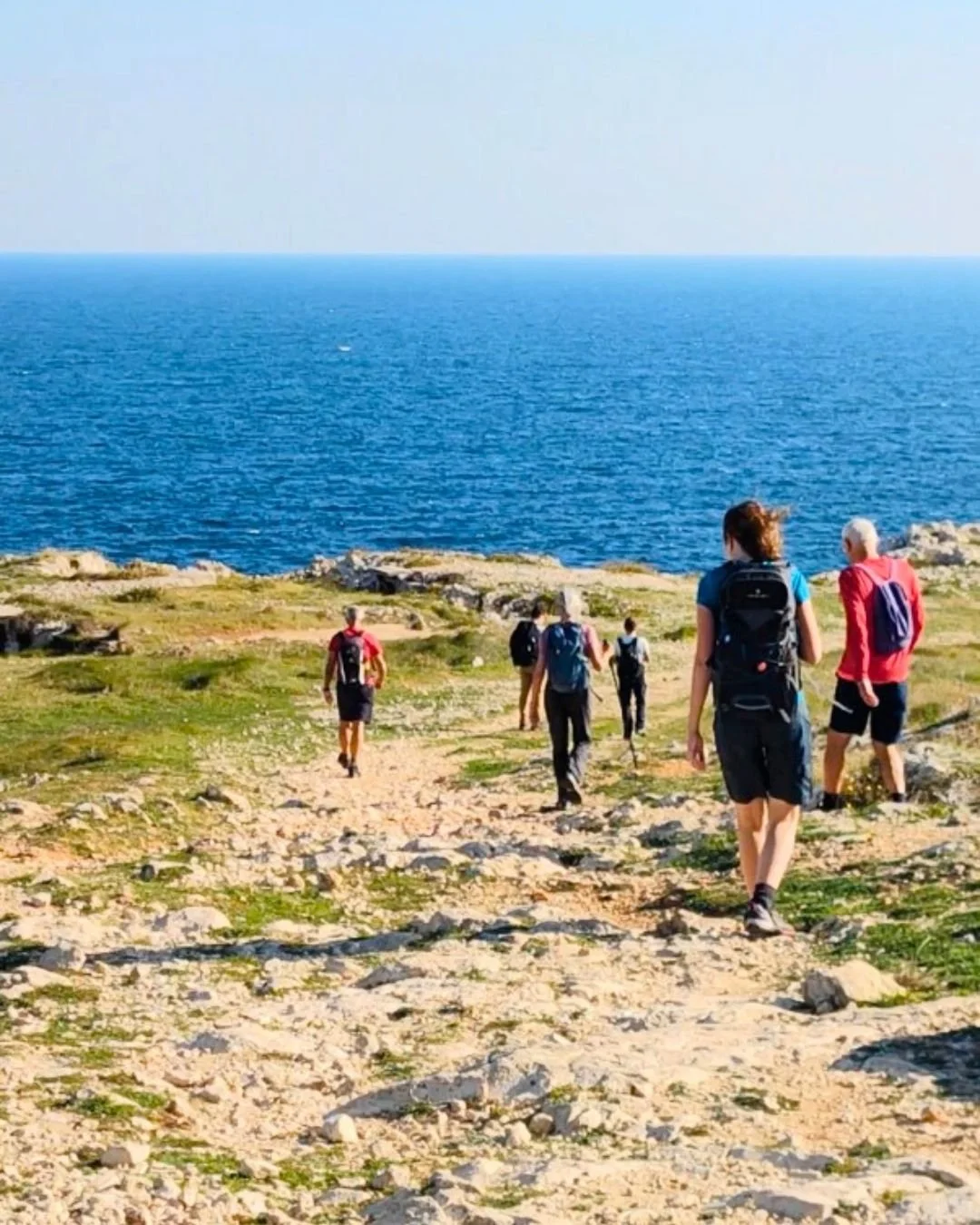 Escursionisti che camminano sul Cammino del Salento con il mare all’orizzonte