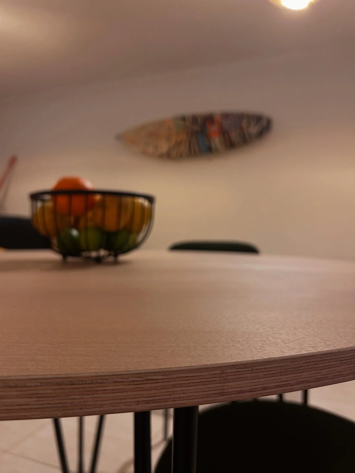 For this project, the goal was a calm, neutral tone that fits the space without standing out too much.
The round dining table is made from oak veneer, oiled in a soft white tone to match the rest of the interior.
The plywood core stays visible at the