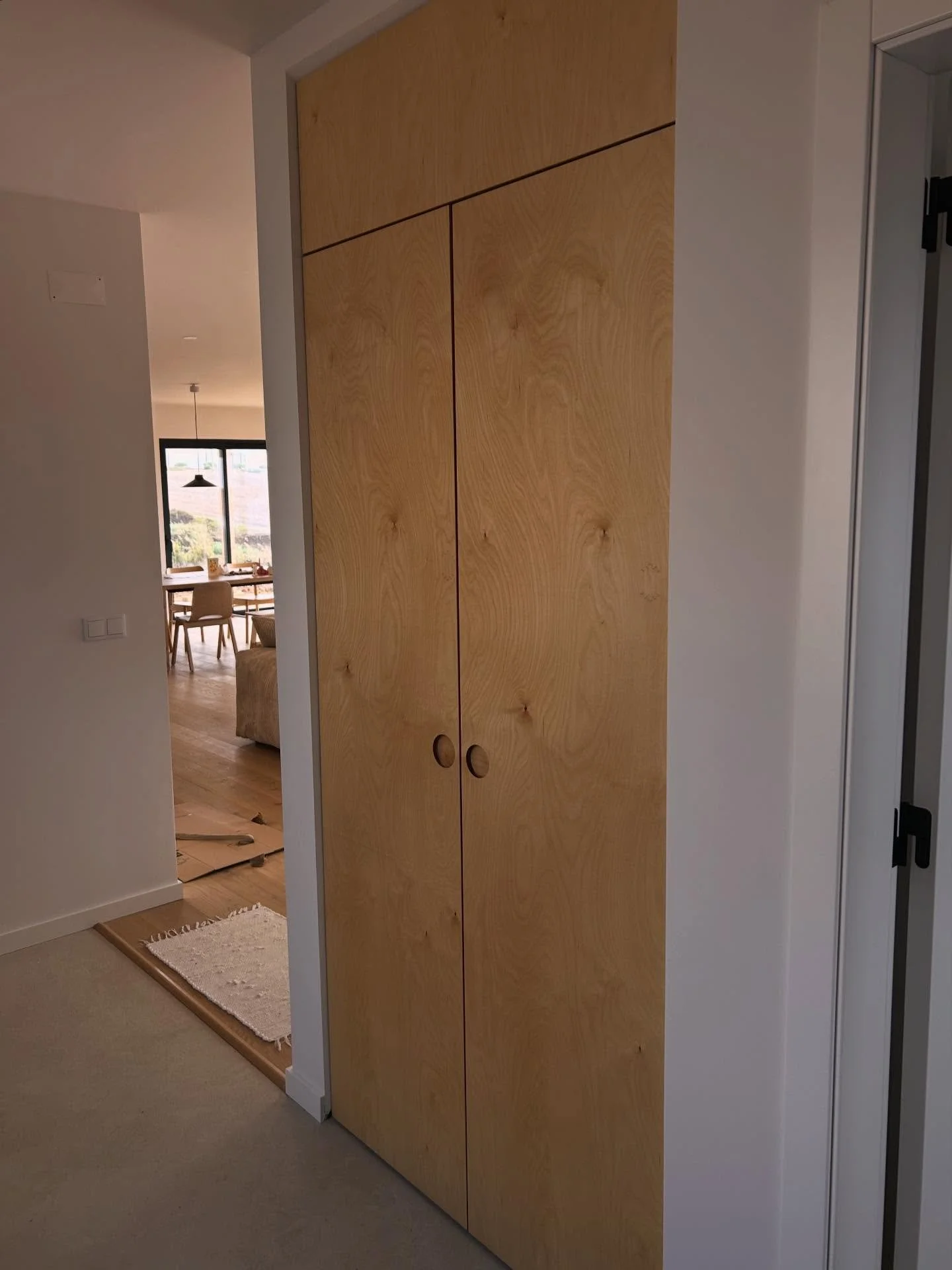 Natural oiled birch plywood, turning the space under the staircase into calm, useful storage.
Routed recessed circle handles, no hardware, just material and proportion.
The cabinet lines align precisely with the door height on the right, so it sits n