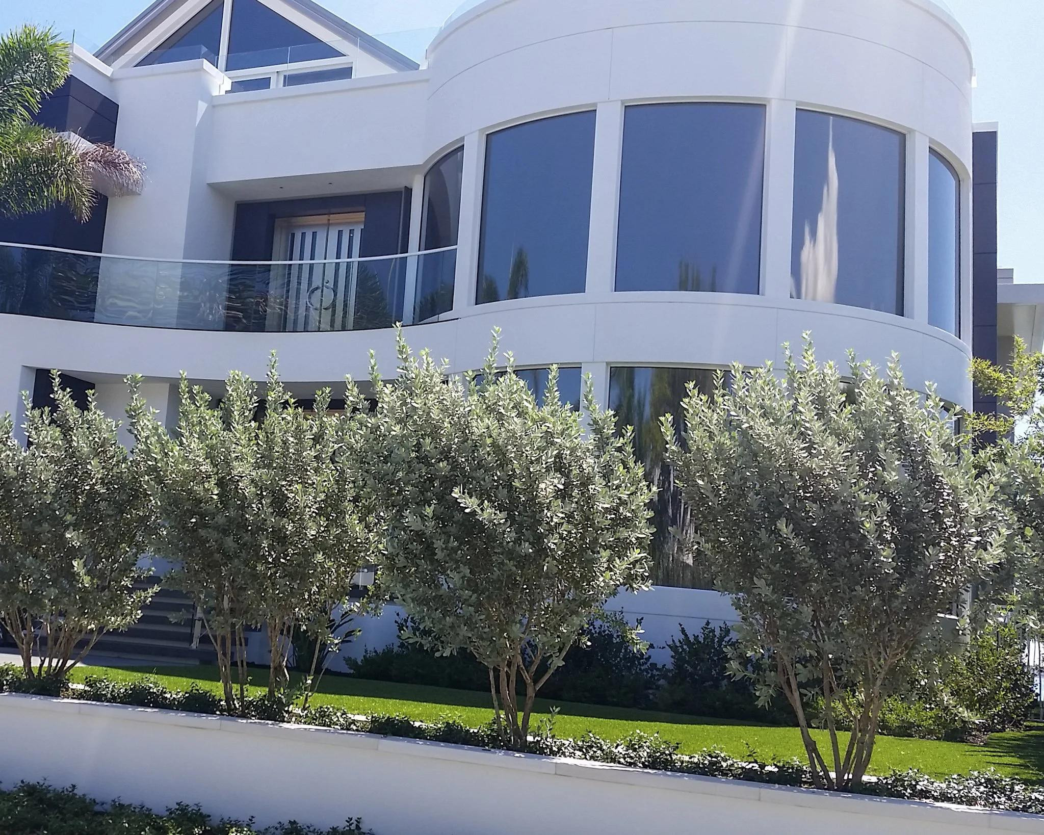 Modern waterfront home in Florida with curved and bent glass features, as seen in US Glass Magazine.