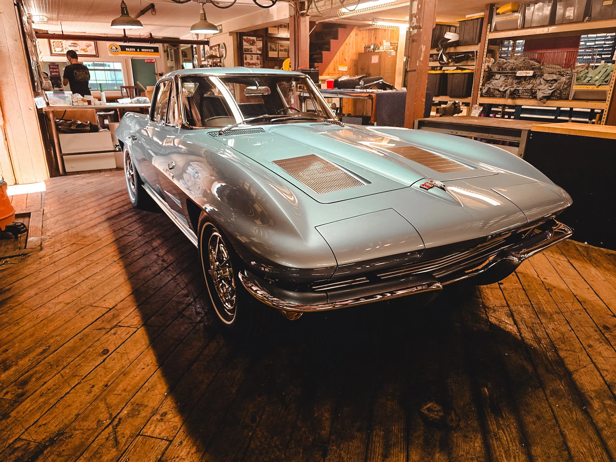 Silver Blue 1963 Corvette three-quarter front view at The Creative Workshop in Dania Beach FL — original windshield and glass restored to factory-clear condition by Glass Restoration Inc. ahead of the 2026 collector car show season