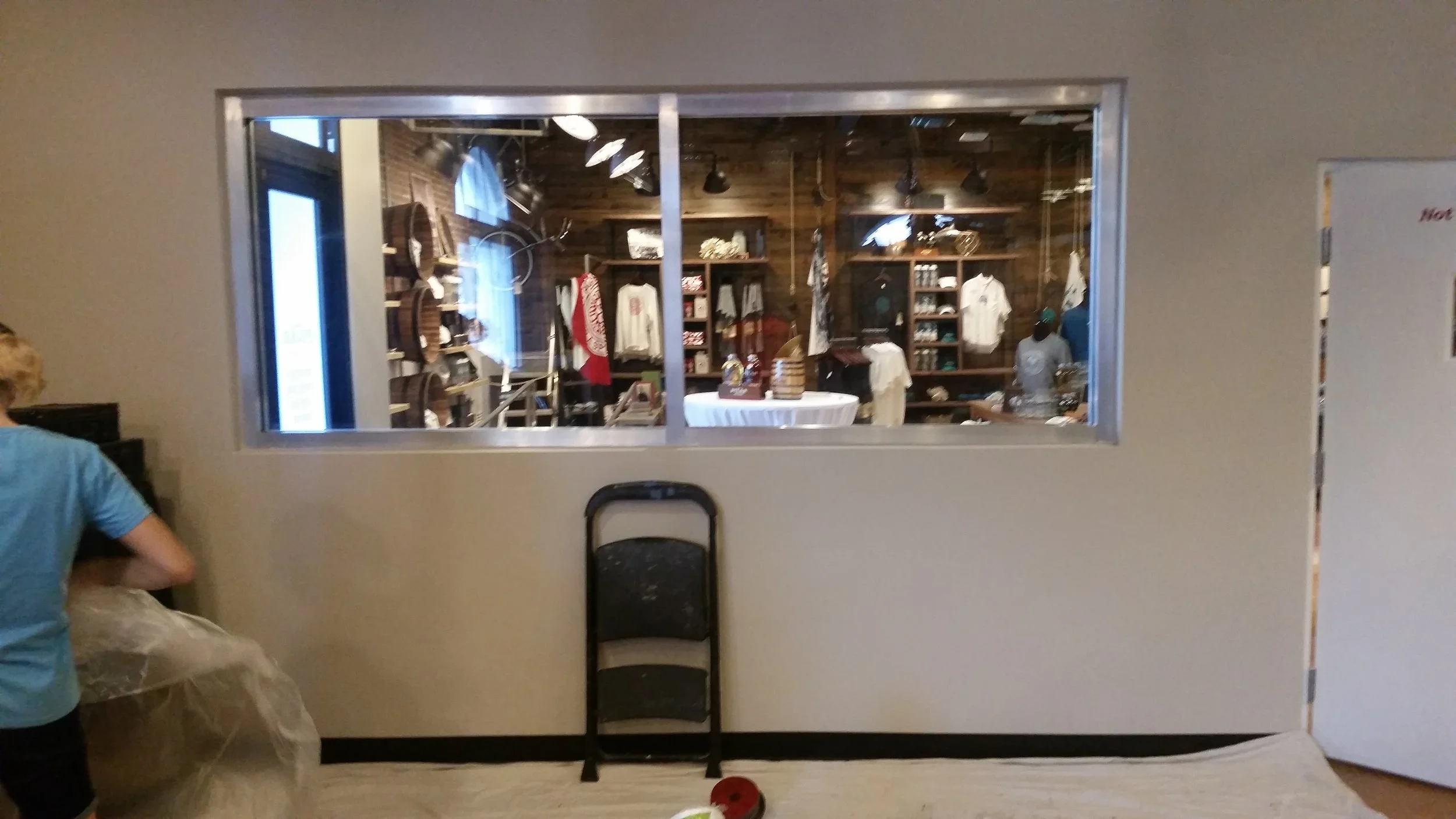 Interior view through fire rated glass partition at Papa's Pilar Rum Distillery, Hemingway Rum Co., Key West FL — restored to optical clarity by Glass Restoration Inc.