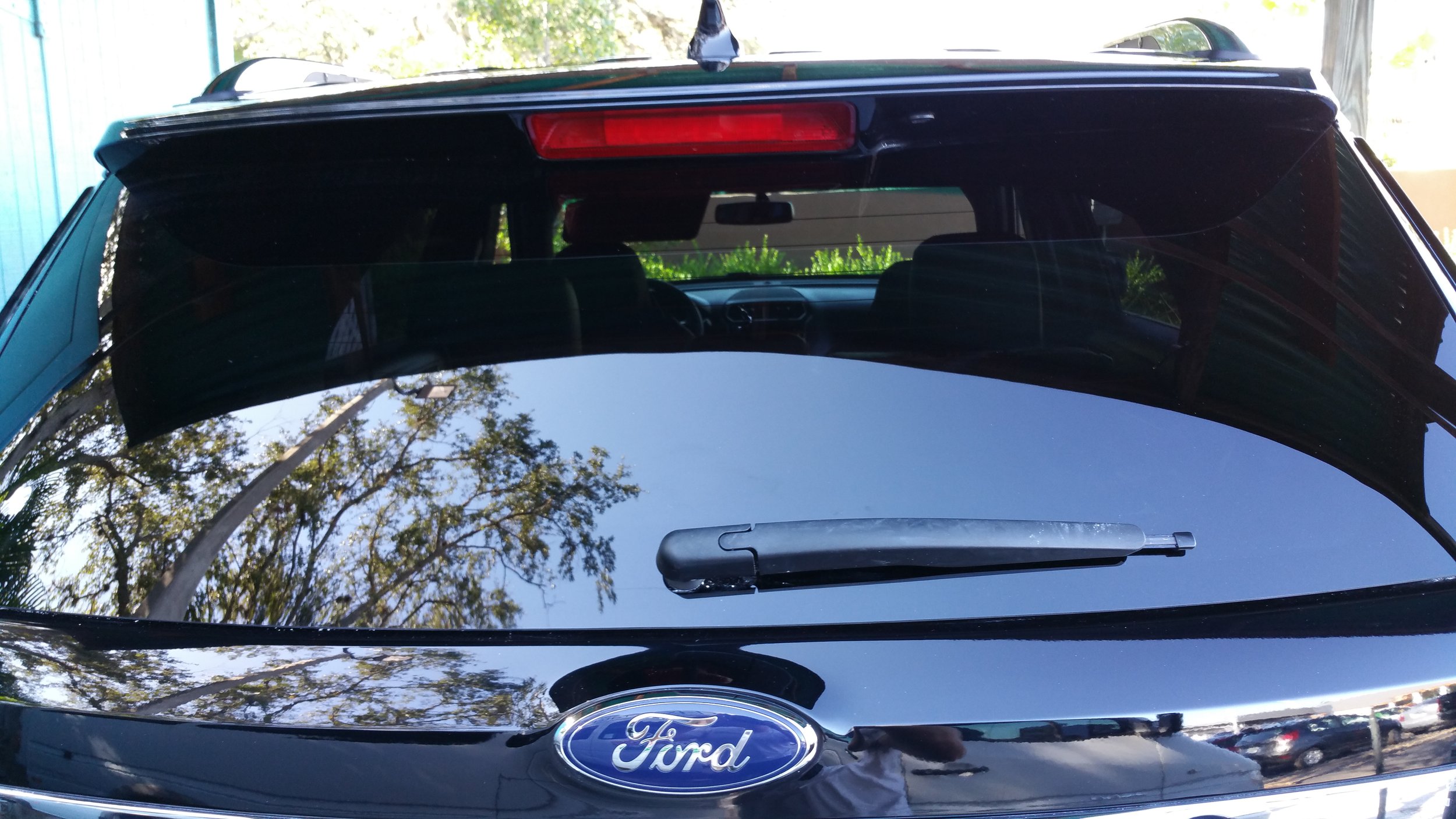Rear view of black Ford SUV with windshield wiper and third brake light.