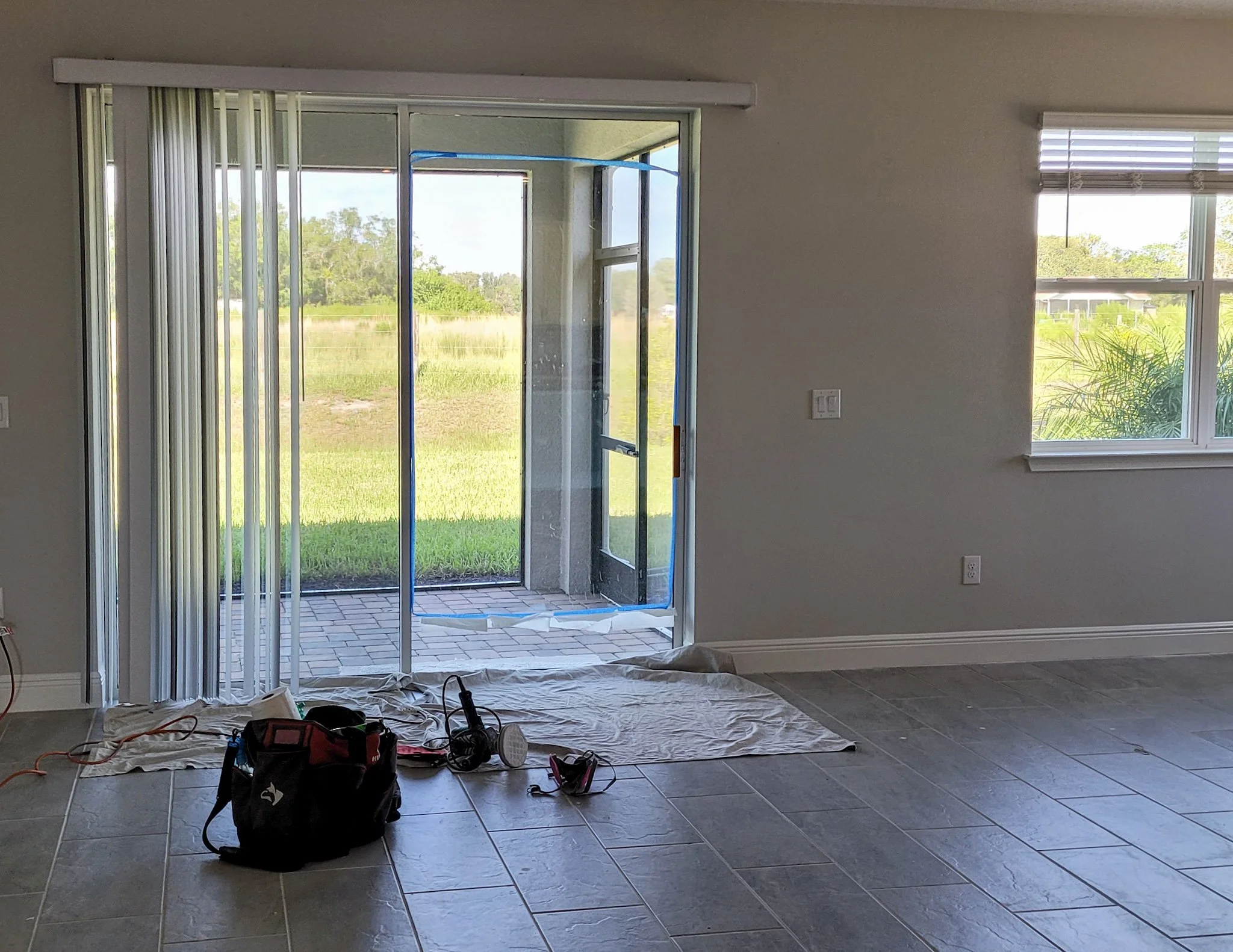 Glass Restoration Inc. professional setup — drop cloth and glass scratch repair tools staged at impact sliding glass doors in Clearwater FL ready for on-site restoration