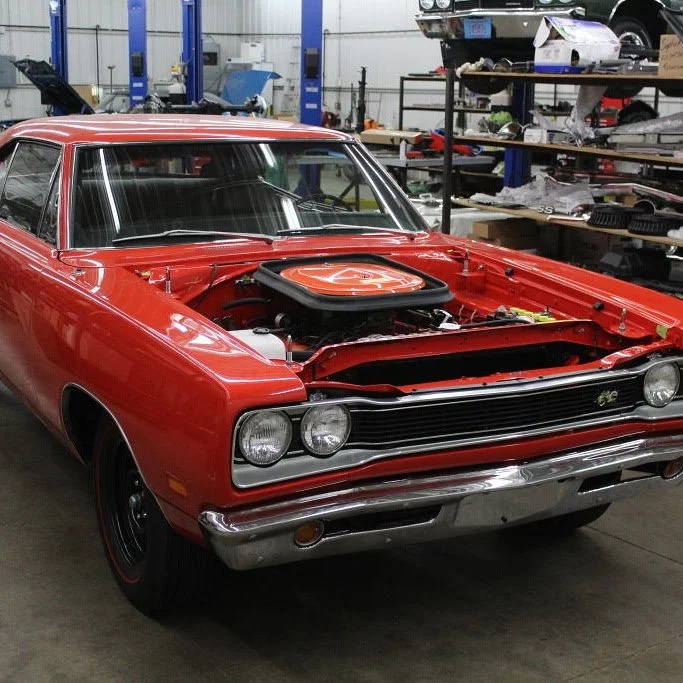 Red Mopar contest car featuring original glass restored by Glass Restoration Inc. in the owner’s shop before competition.