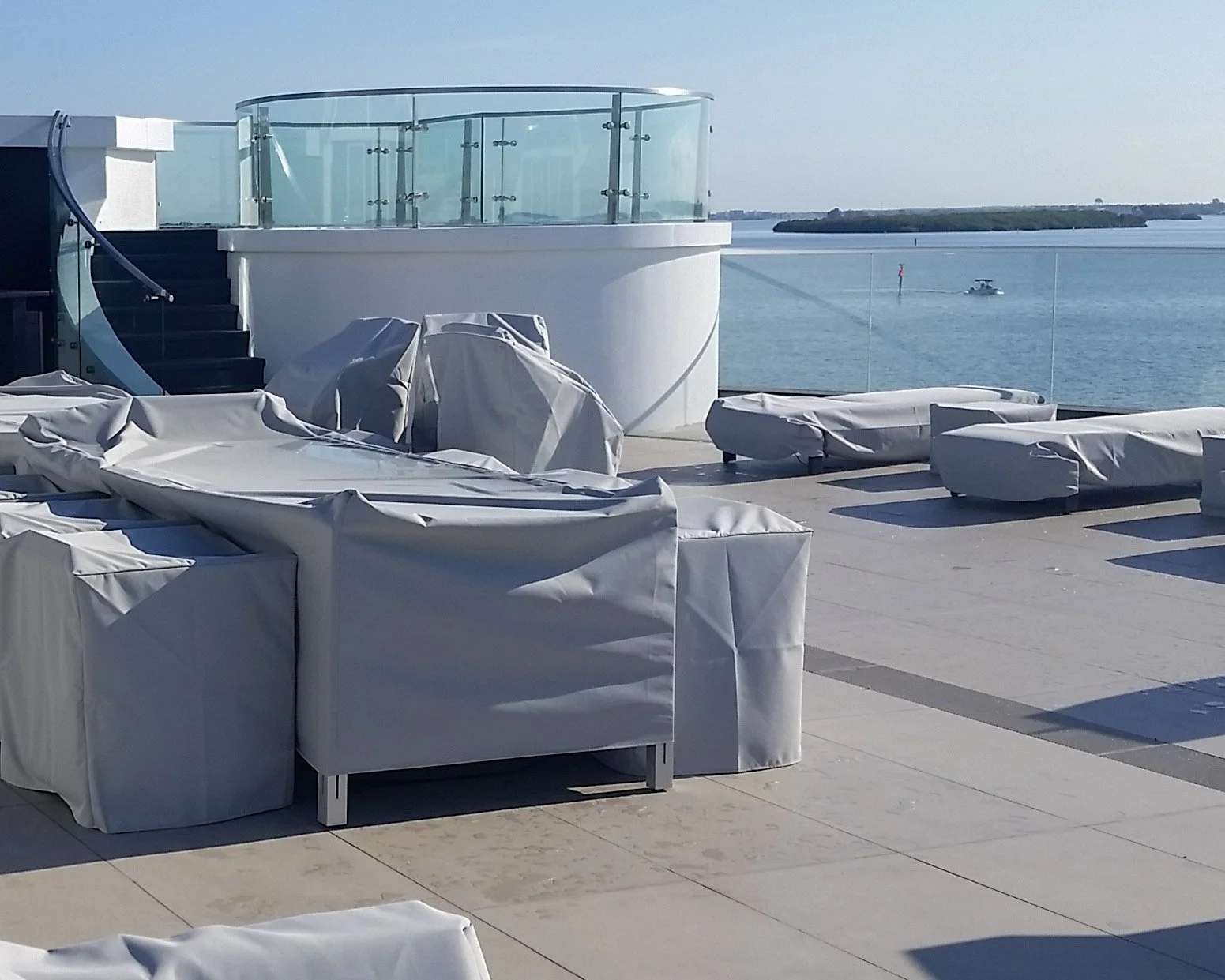 Waterfront home with curved glass balcony and terrace — Glass Restoration Inc. serves luxury Gulf Coast residences with on-site curved glass scratch repair and restoration.
