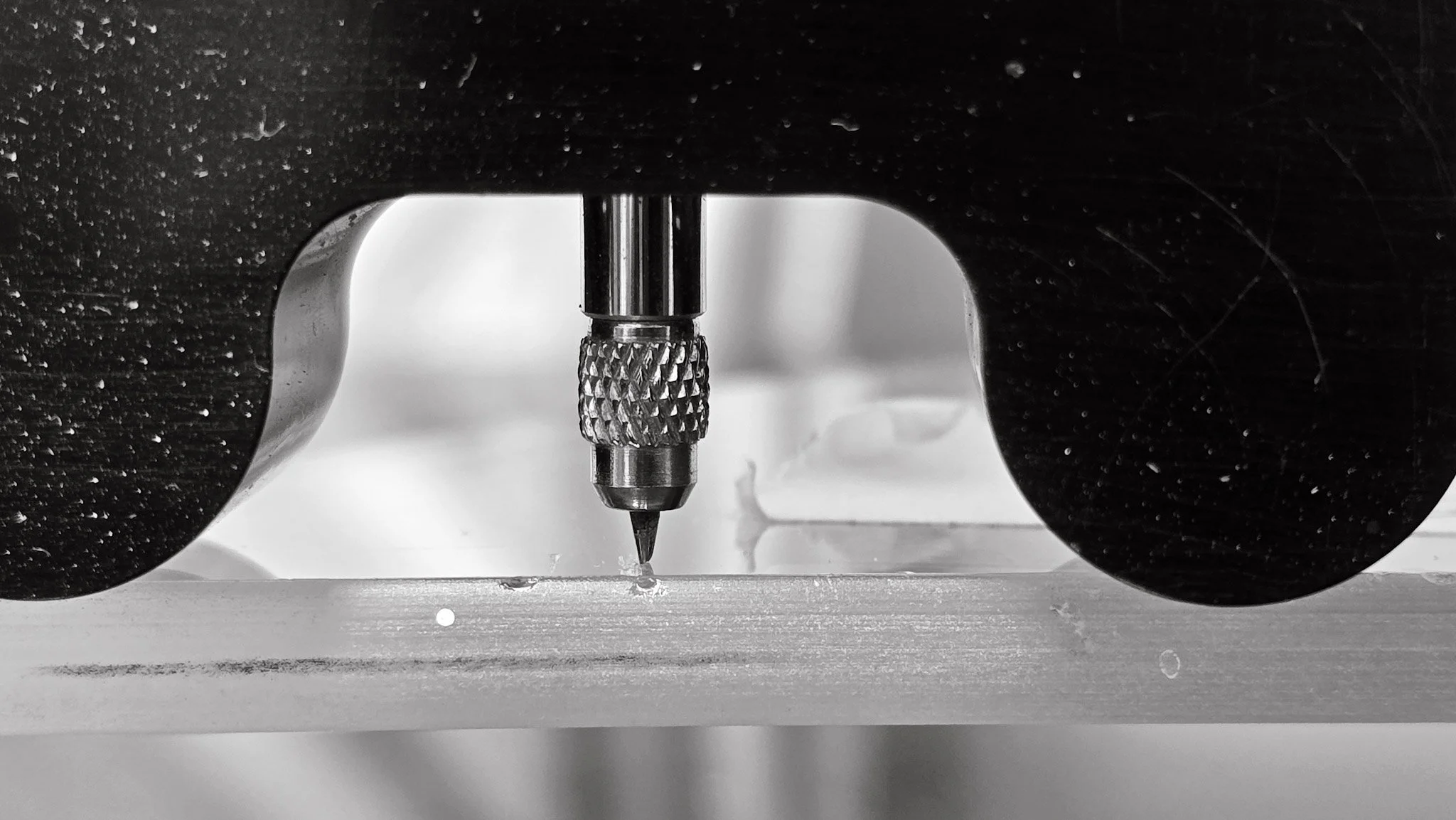 Measuring glass scratch depth with a micrometer to ensure precision restoration for oversized architectural glass.