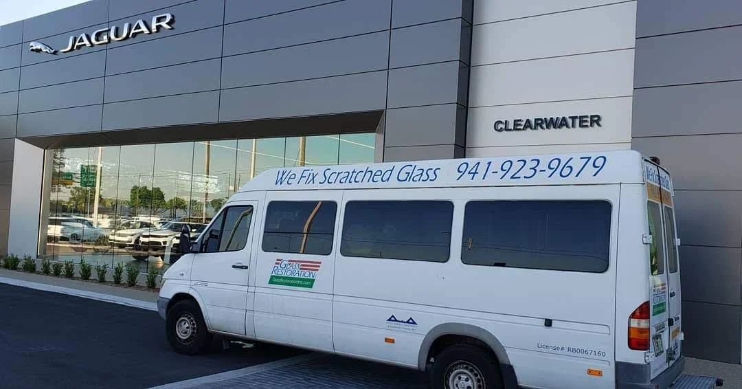 Glass Restoration Inc. work van in front of Jaguar of Clearwater — verified commercial automotive dealership glass restoration serving Clearwater and Pinellas County FL