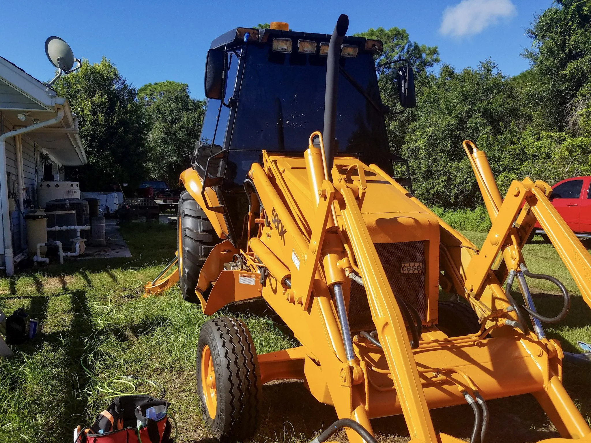Same backhoe cab glass fully restored to factory-clear optical condition by Glass Restoration Inc. — professional heavy equipment glass restoration serving construction fleets and equipment rental companies throughout Florida without replacement