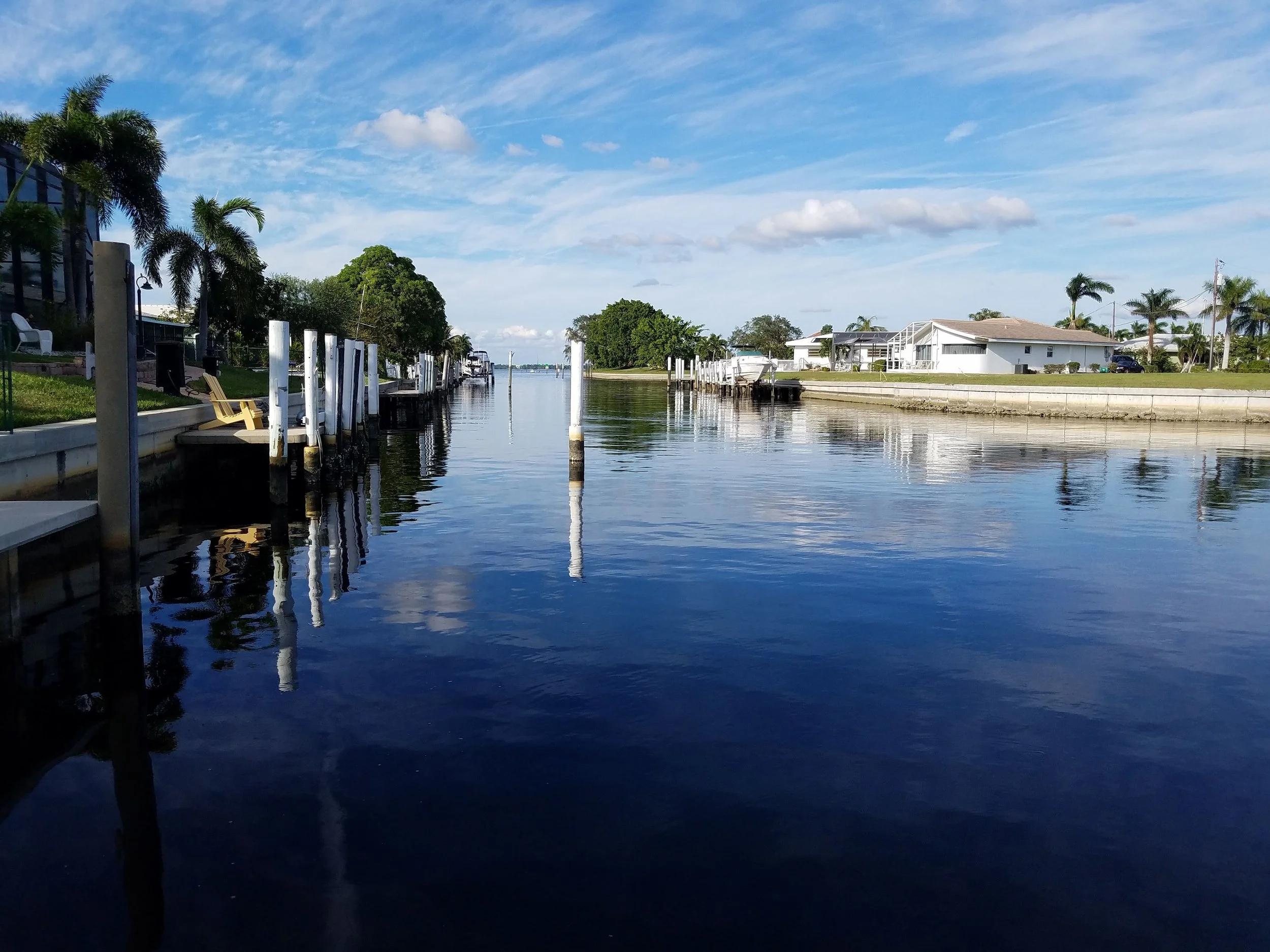 Vivid, crystal-clear view of a Cape Coral canal through a fully restored sliding glass door, where Glass Restoration Inc. removes salt-air etching and construction scratches from waterfront estates.
