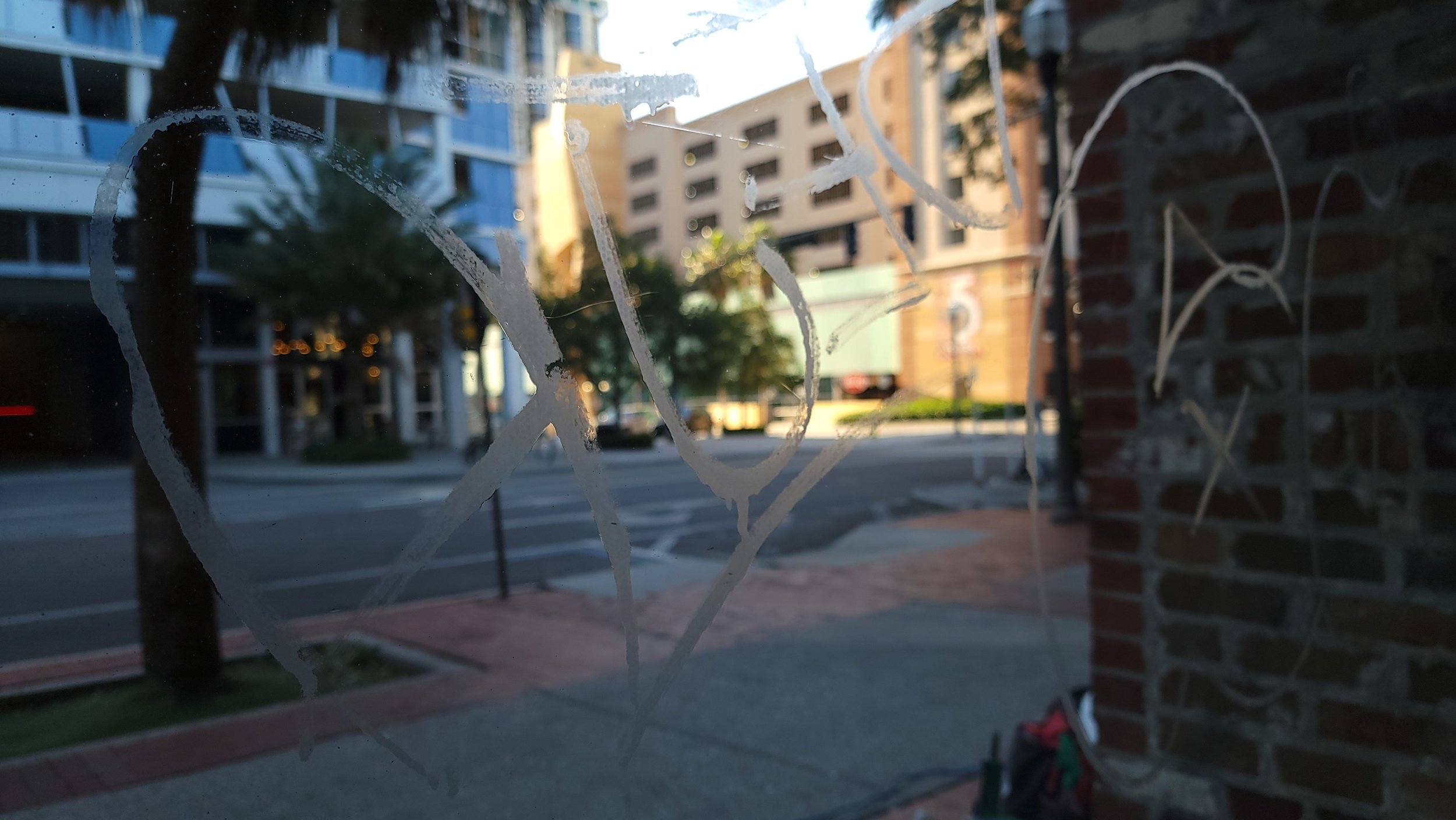 Graffiti on glass window with urban street view in background