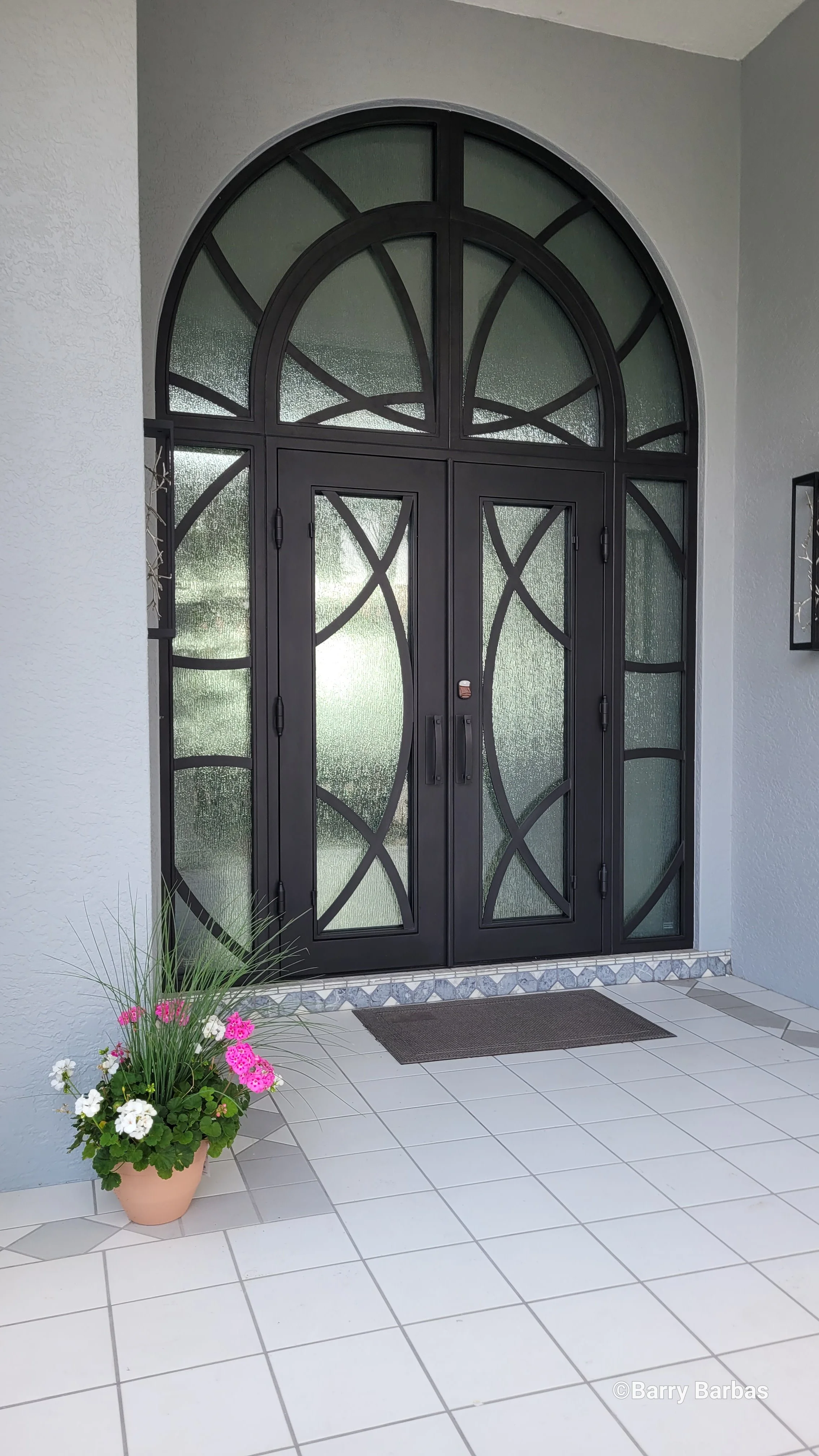 Large decorative iron and glass entry door with two side lites and circle top — the type of architectural glass that Glass Restoration Inc. restores on-site for Mulberry and Polk County FL homeowners without replacement