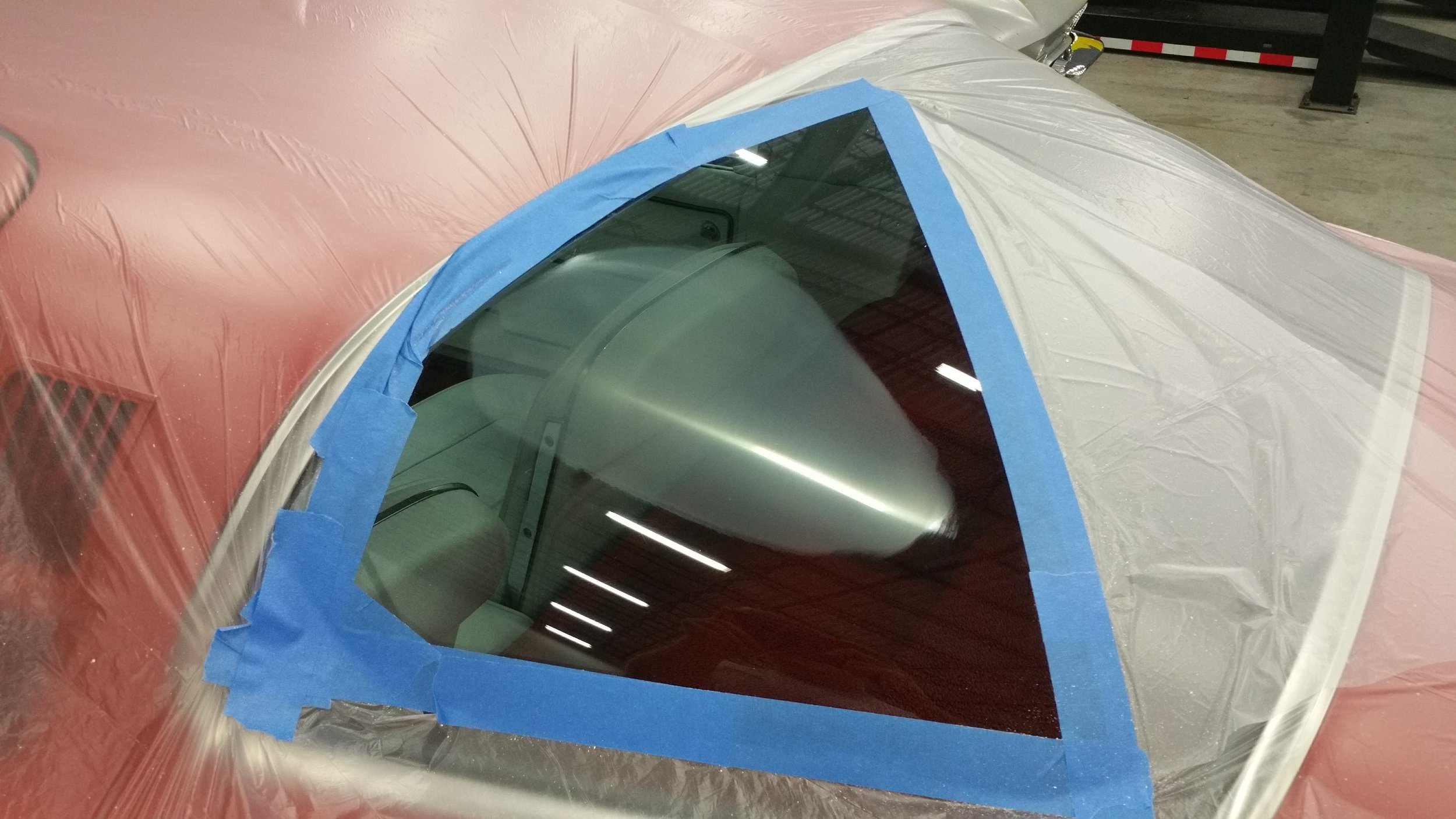Car window with blue masking tape, plastic covering