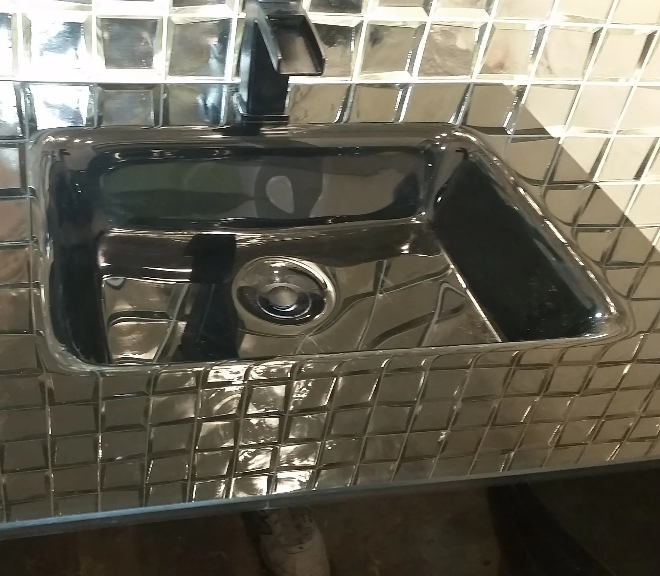 The finished result: a perfectly restored black glass sink in a Sarasota luxury condo; 100% scratch removal and a factory-brilliant, distortion-free finish.