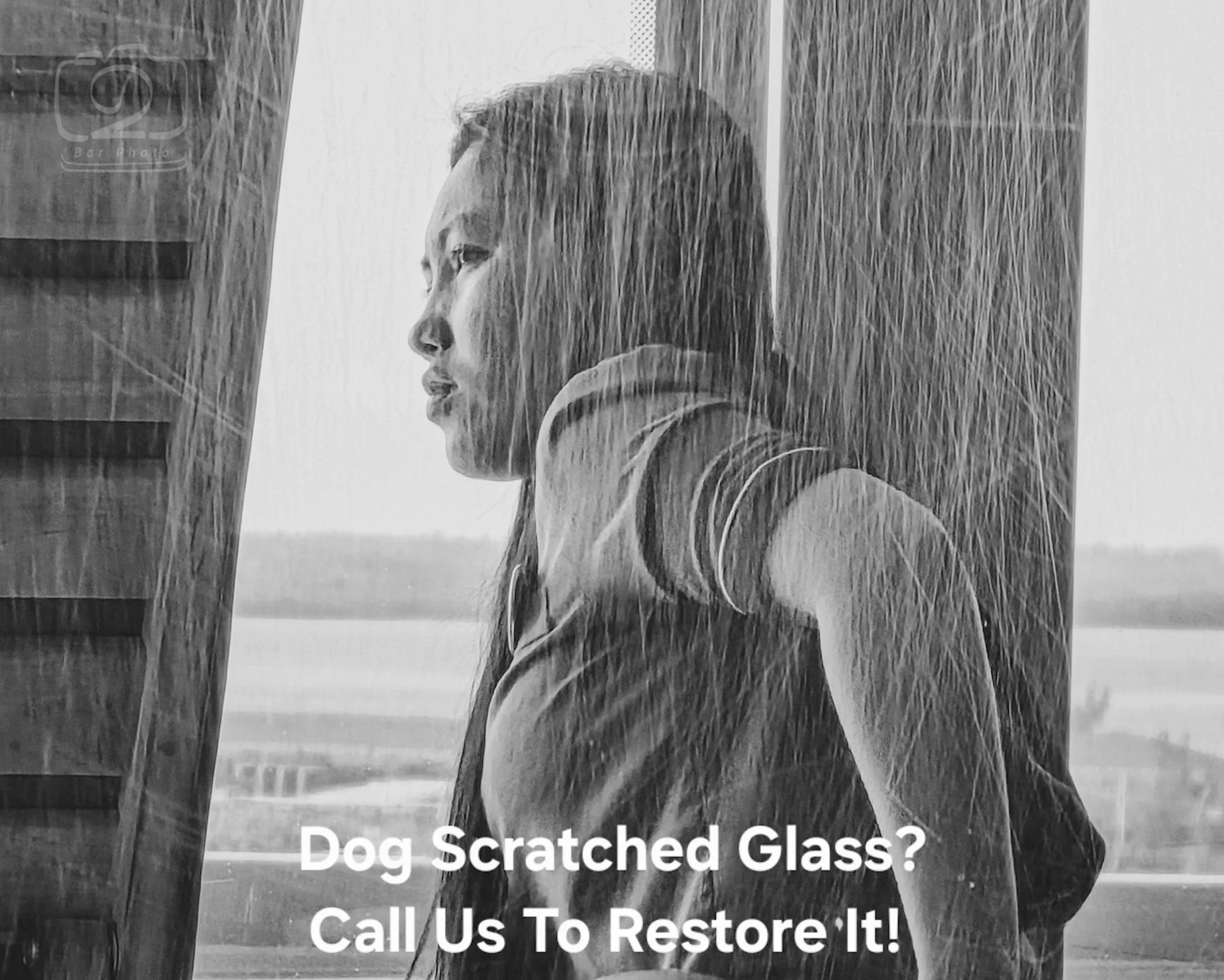 View through a dog-scratched sliding glass door in monochrome — the scratches visible across the entire frame illustrate the damage that Glass Restoration Inc. removes on-site without replacement