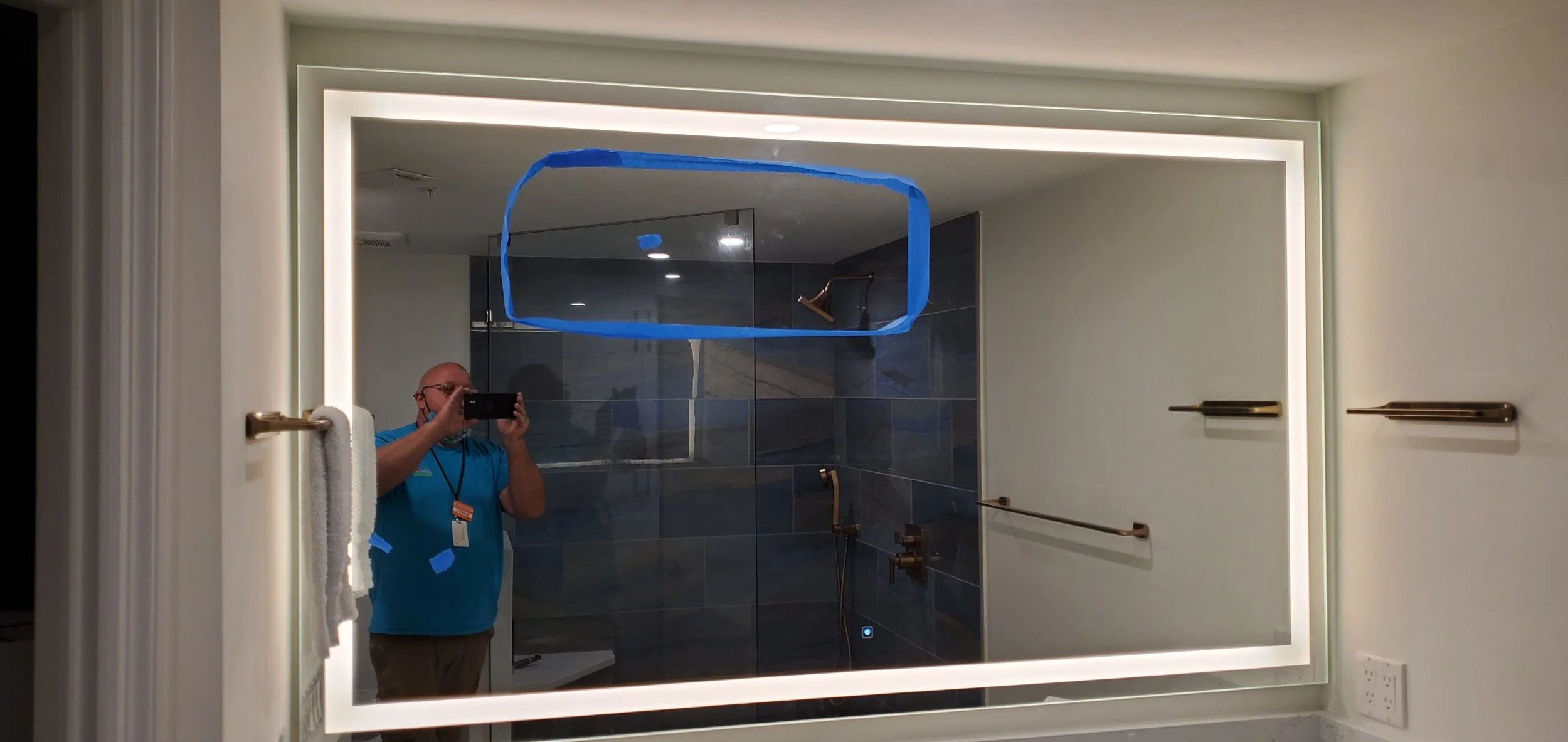 Glass Restoration Inc. repairing a long scratch on a large mirror with integrated light ribbon — in-progress professional mirror scratch removal serving Florida homeowners and commercial properties throughout the Gulf Coast