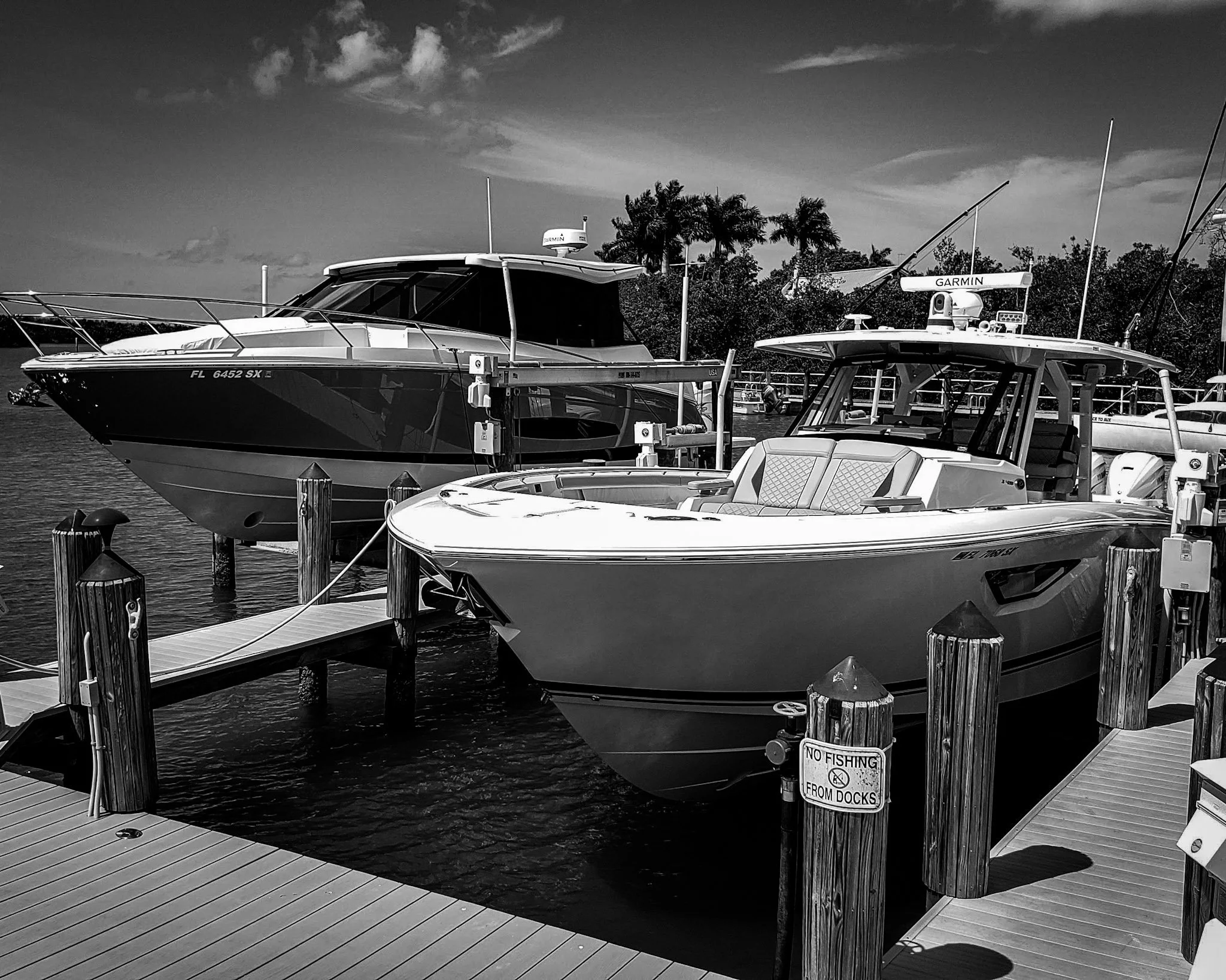 Two boats docked at a South Gulf Cove canal-front home — Glass Restoration Inc. serves the boating community throughout South Gulf Cove's 55-mile navigable canal network, restoring vessel glass and canal-front home windows on site.