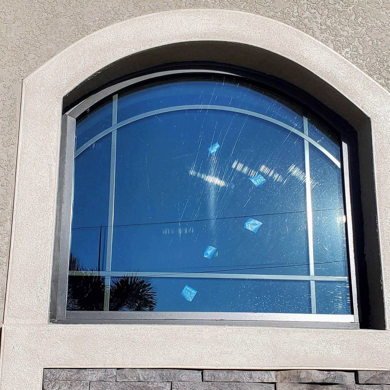 Deep scratches on a residential sliding glass door before professional restoration in Naples, Florida.