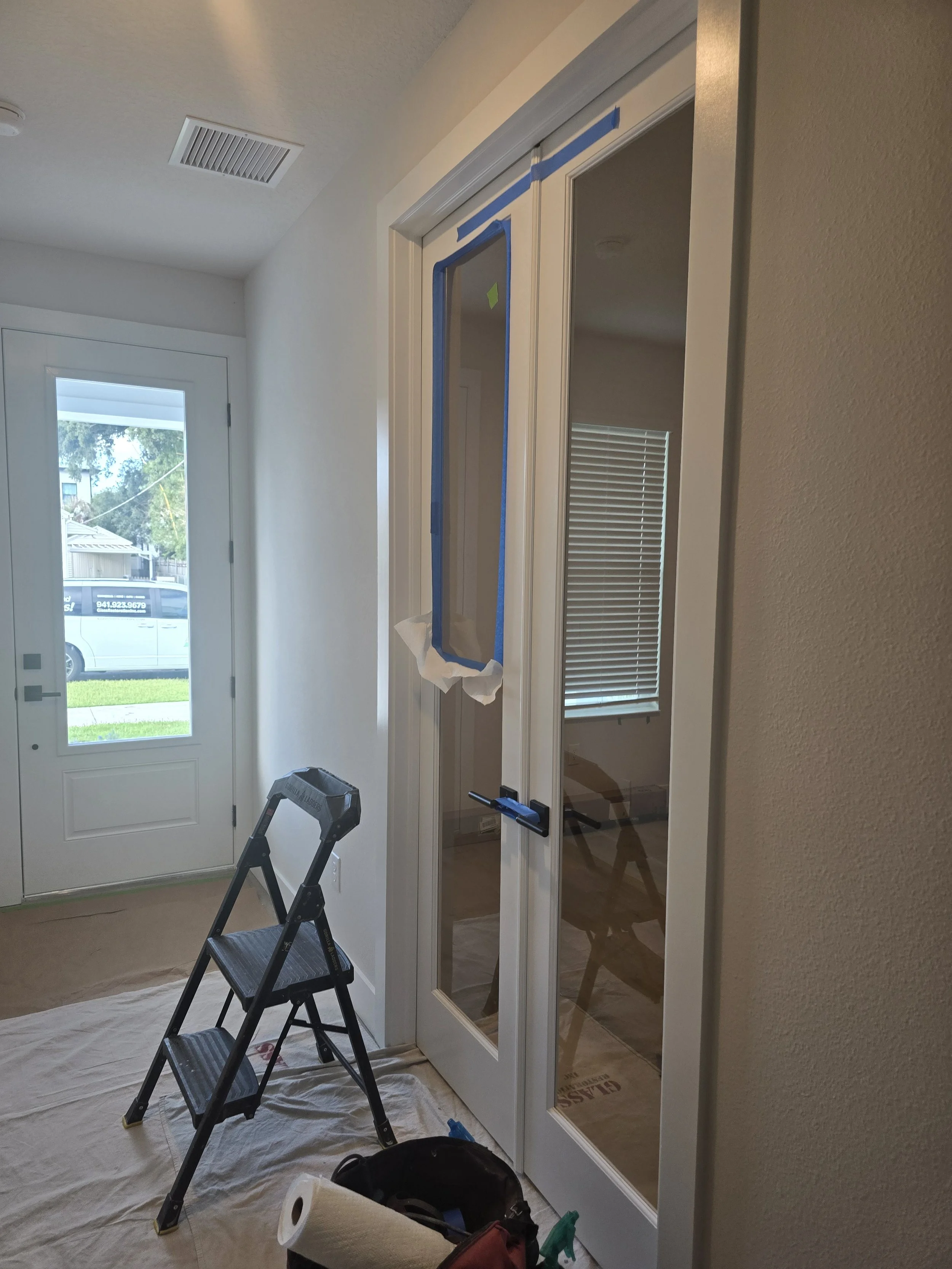 Glass Restoration Inc. work stool and tools positioned in front of a double French interior full lite door with scratches ready for professional on-site restoration — serving Bartow FL homeowners and new construction builders in Polk County
