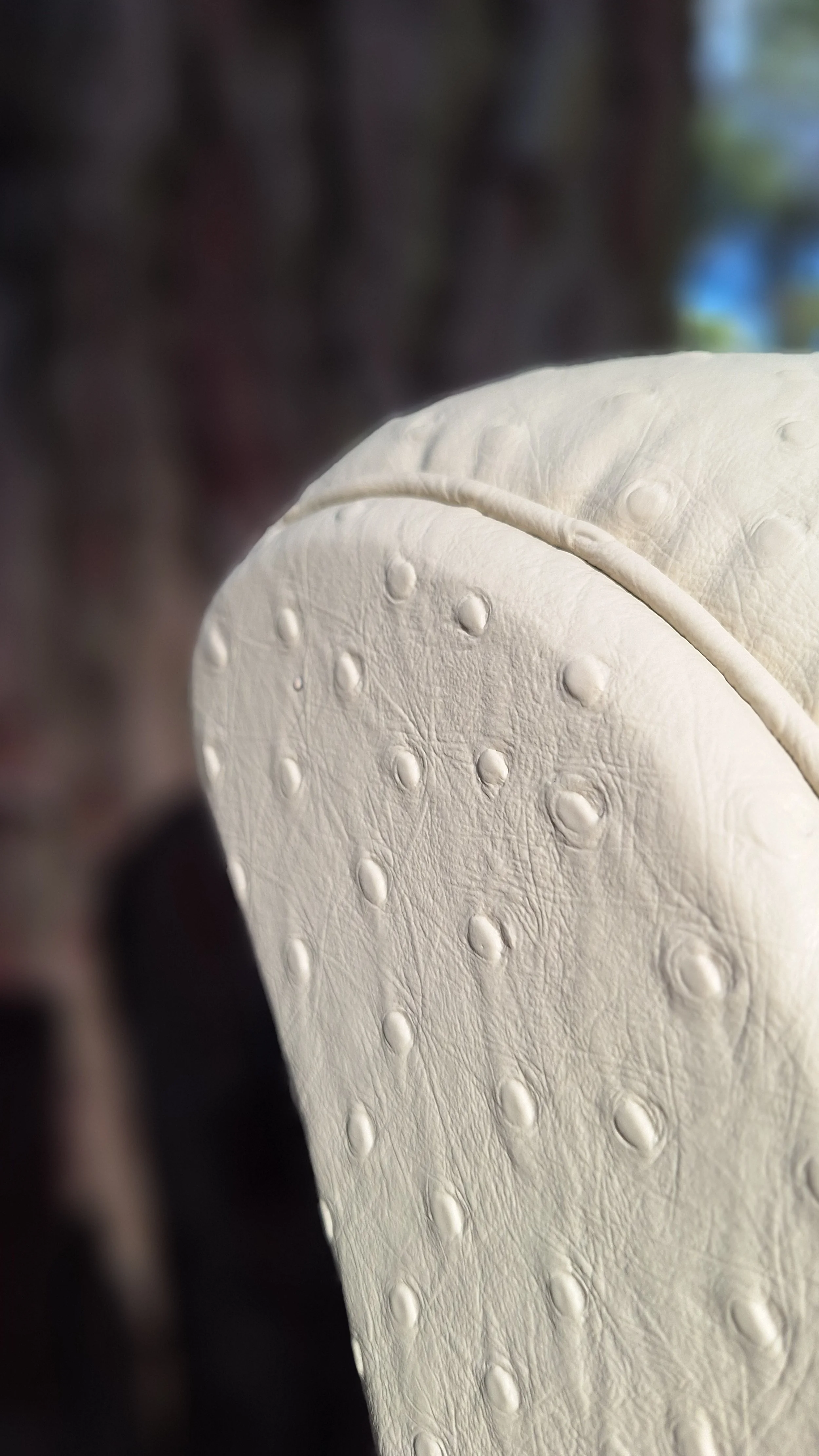 Fauteuil club art nouveau détail accoudoir en photo dans la foret des landes. Réalisé en cuir végétal, impression autruche couleur mascarpone, issus du recyclage de déchets de l'industrie forestière (sciure de bois), visible à Sanguinet, Nord des Lan