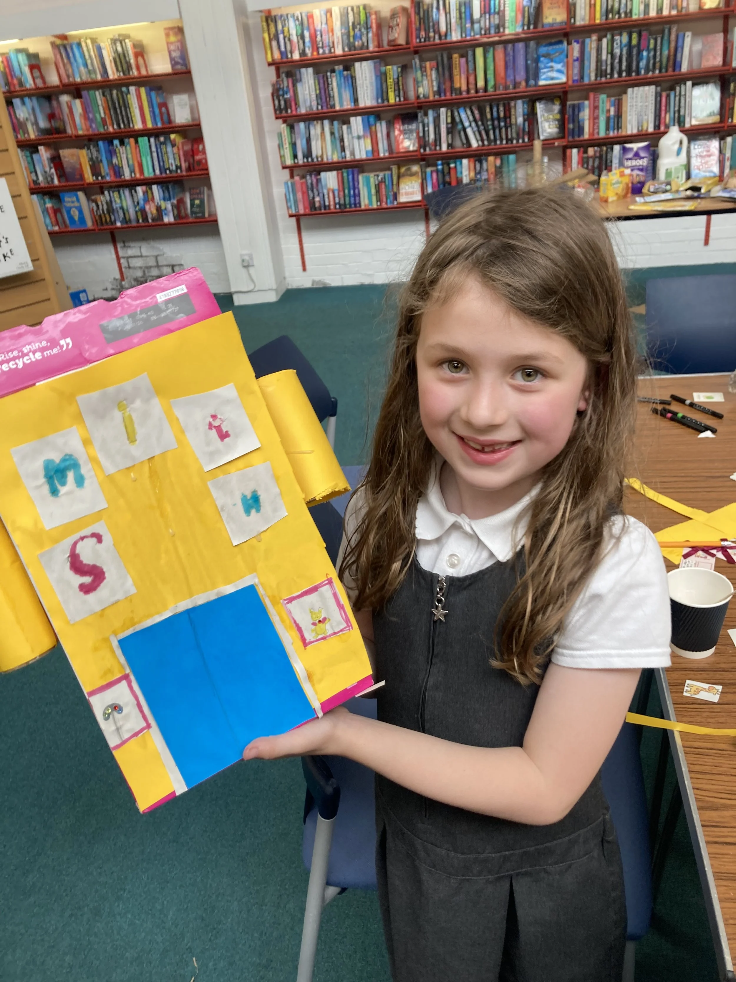 Happy child showing off her new artwork from recycled materials