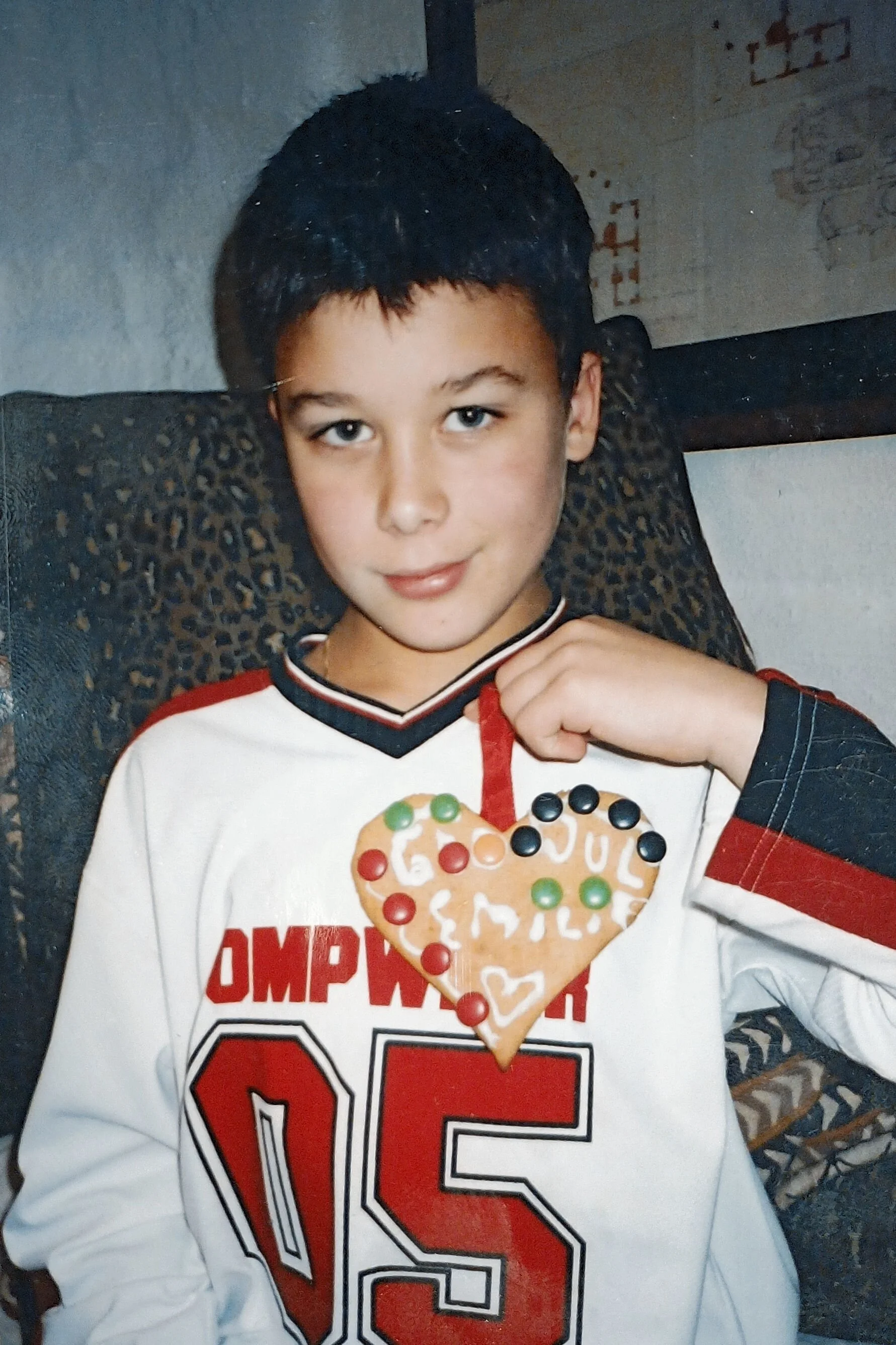 Bilde av en gutt som holder ett hjerte pepperkake med godteri