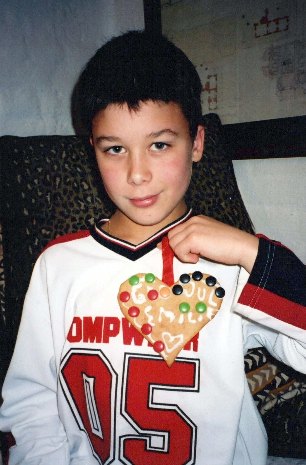 Bilde av en gutt som holder ett hjerte pepperkake med godteri