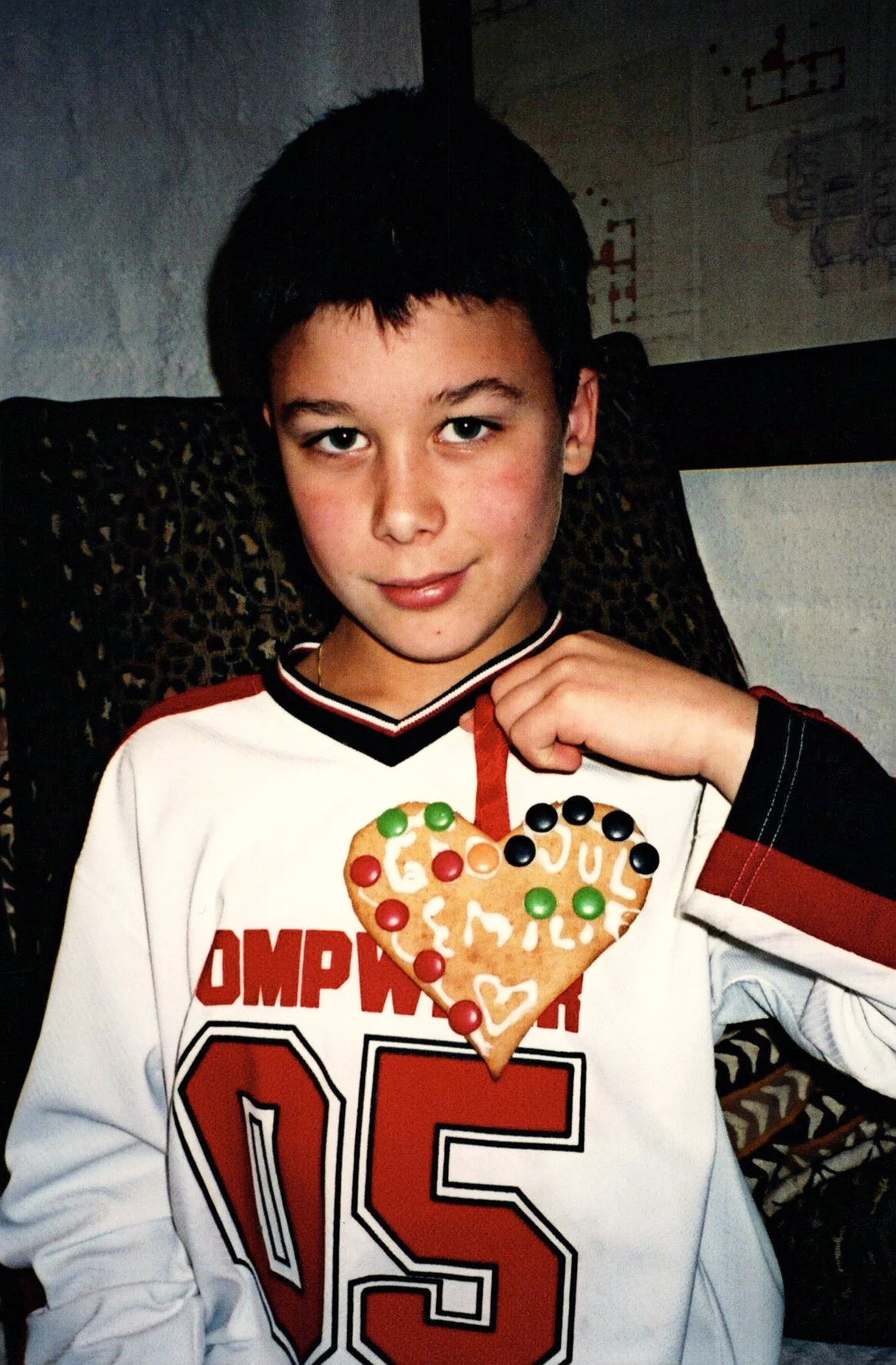 Bilde av en gutt som holder ett hjerte pepperkake med godteri