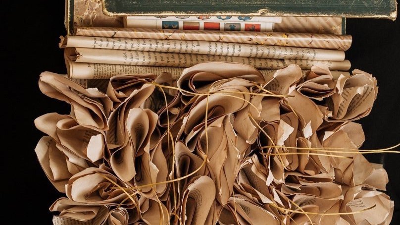 Une pile de journaux et de papiers froissés avec des ficelles