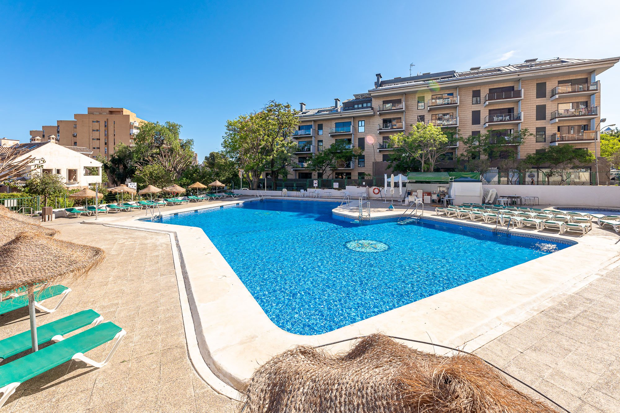 SpainBreaks | The swimming pool area, surrounded by lounge chairs and umbrellas.