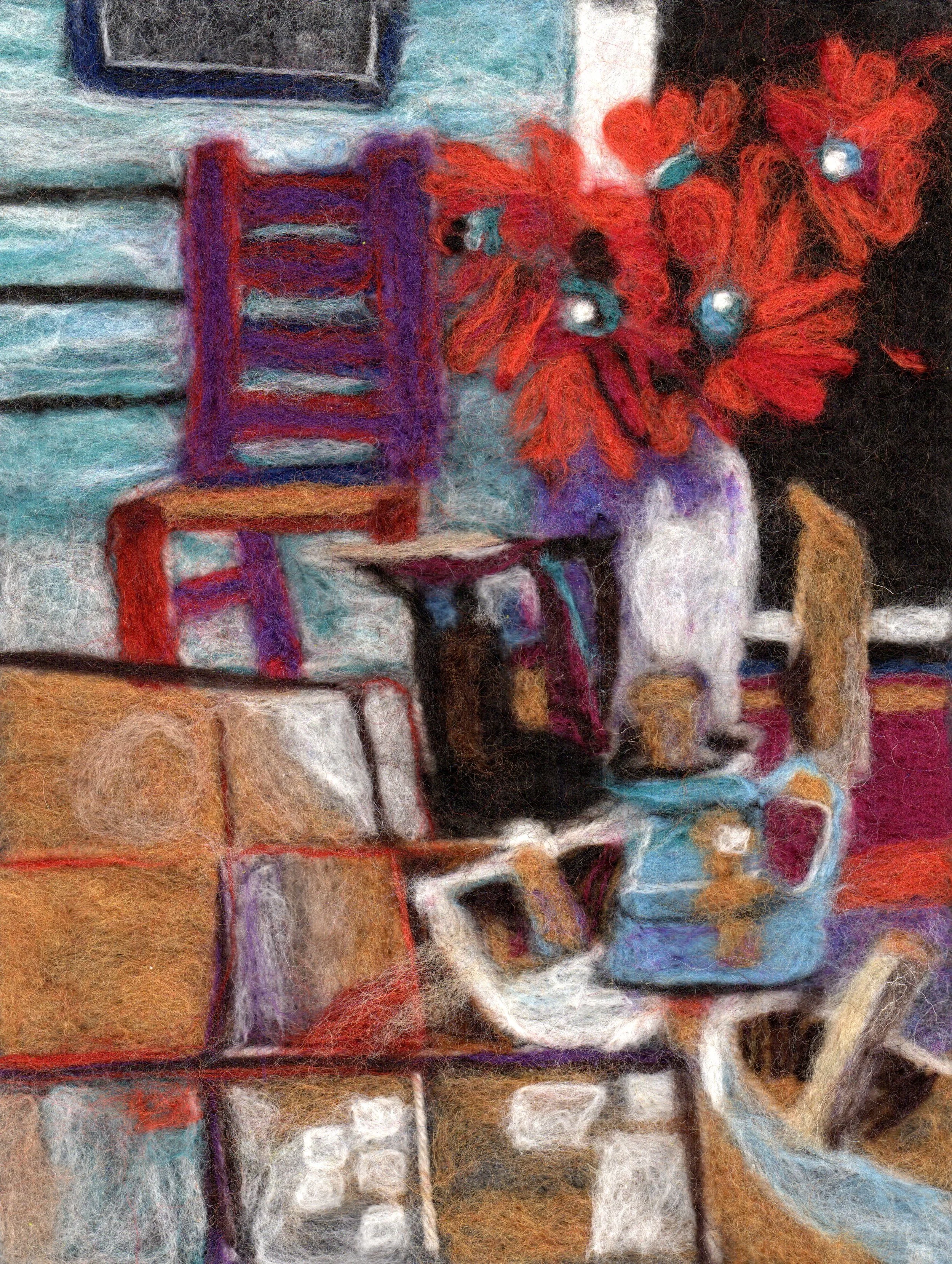 Needle felted wool image of a chair and flowers on a porch in brown, red, white, light blue, and purple