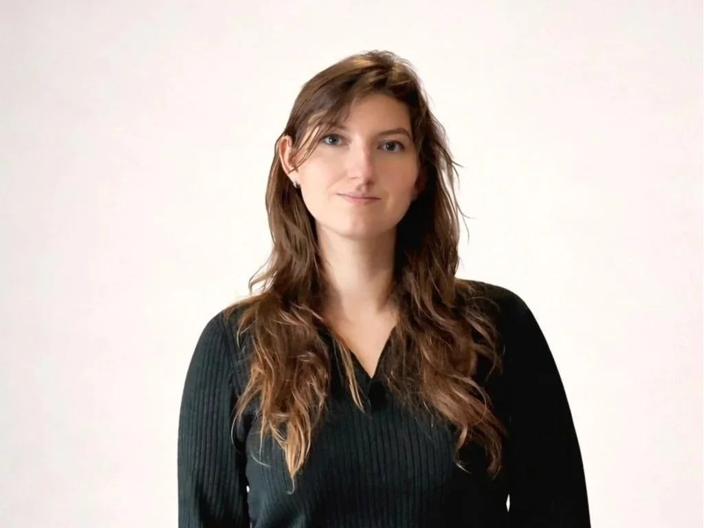 Une jeune femme souriante portant une robe à fleurs. 