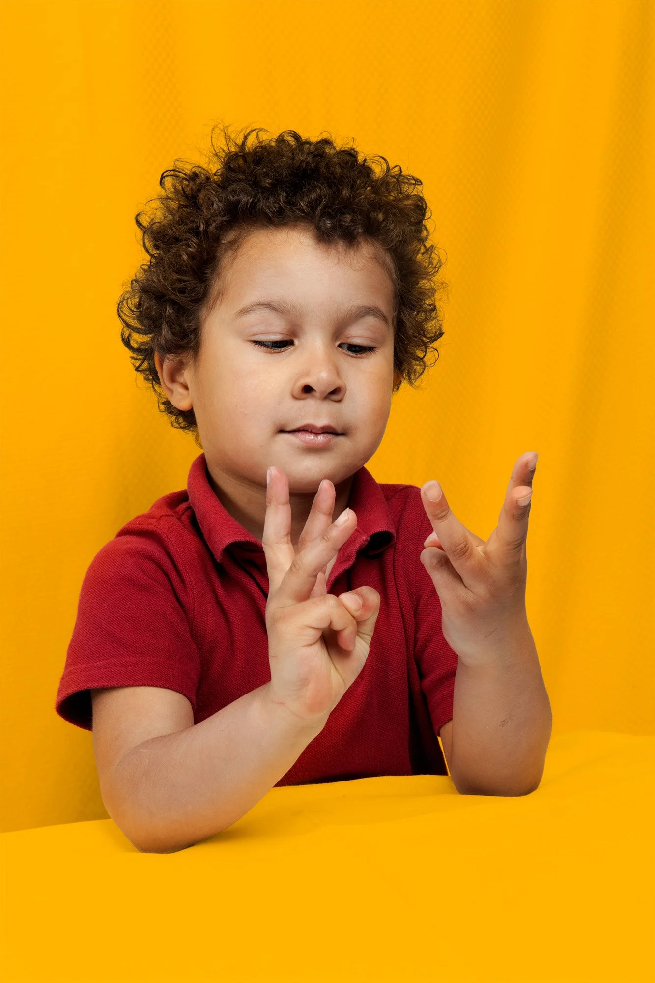 A young boy learning american sign language